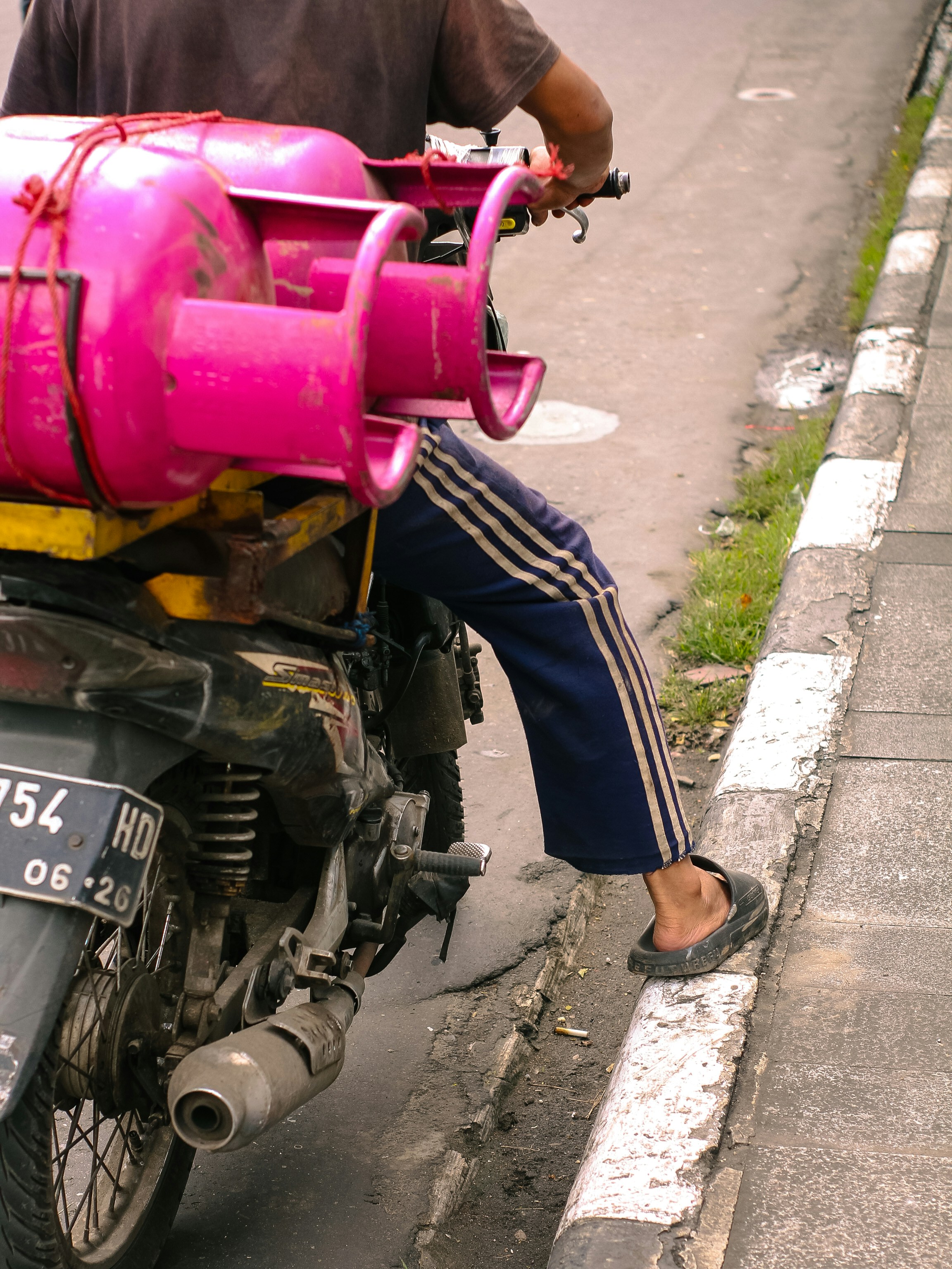 Mann fährt Motorrad mit rosa Benzintanks