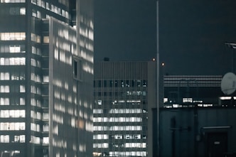 Modern skyscrapers illuminated at night with city lights.