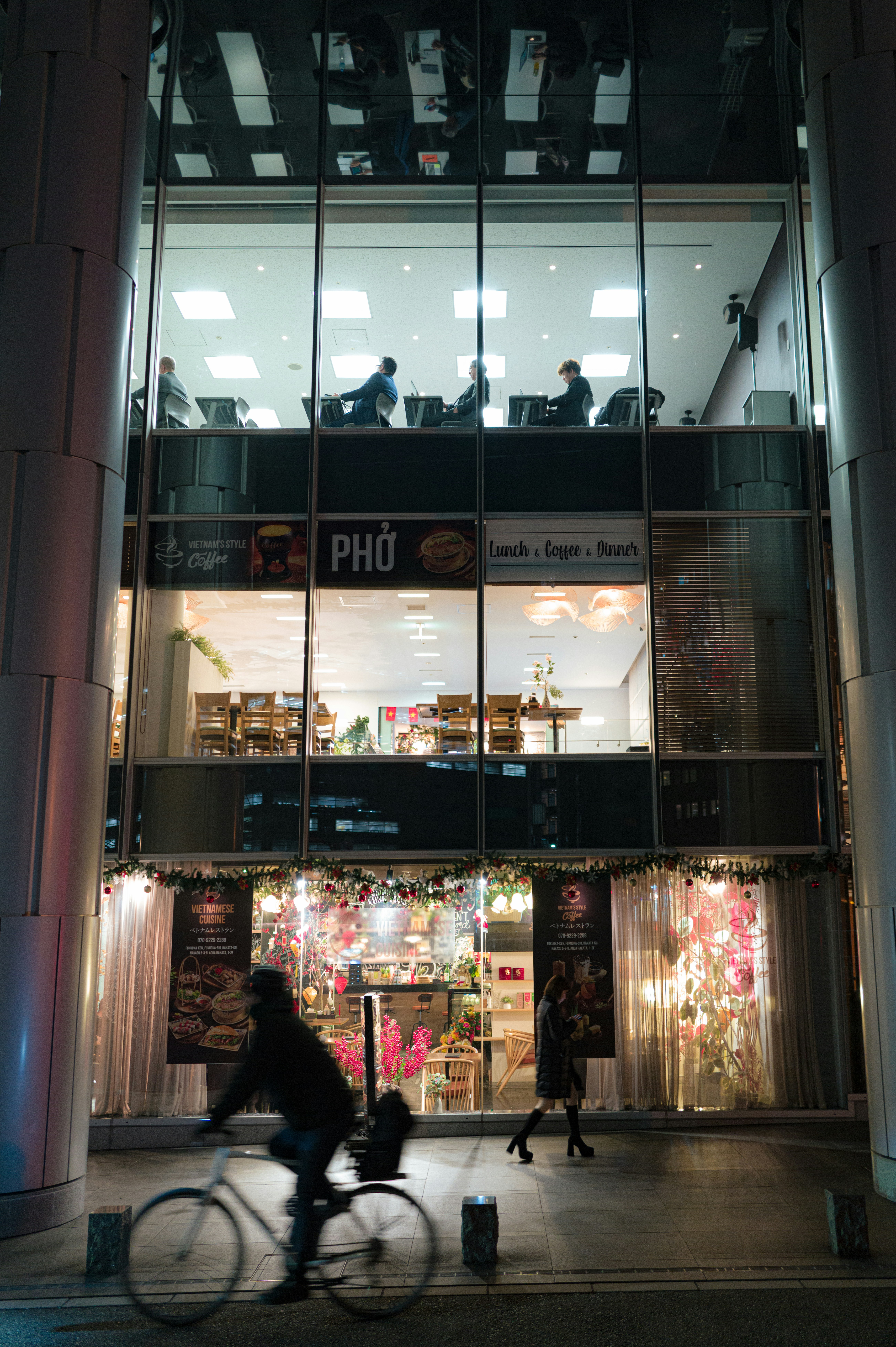 People working in modern office building at night
