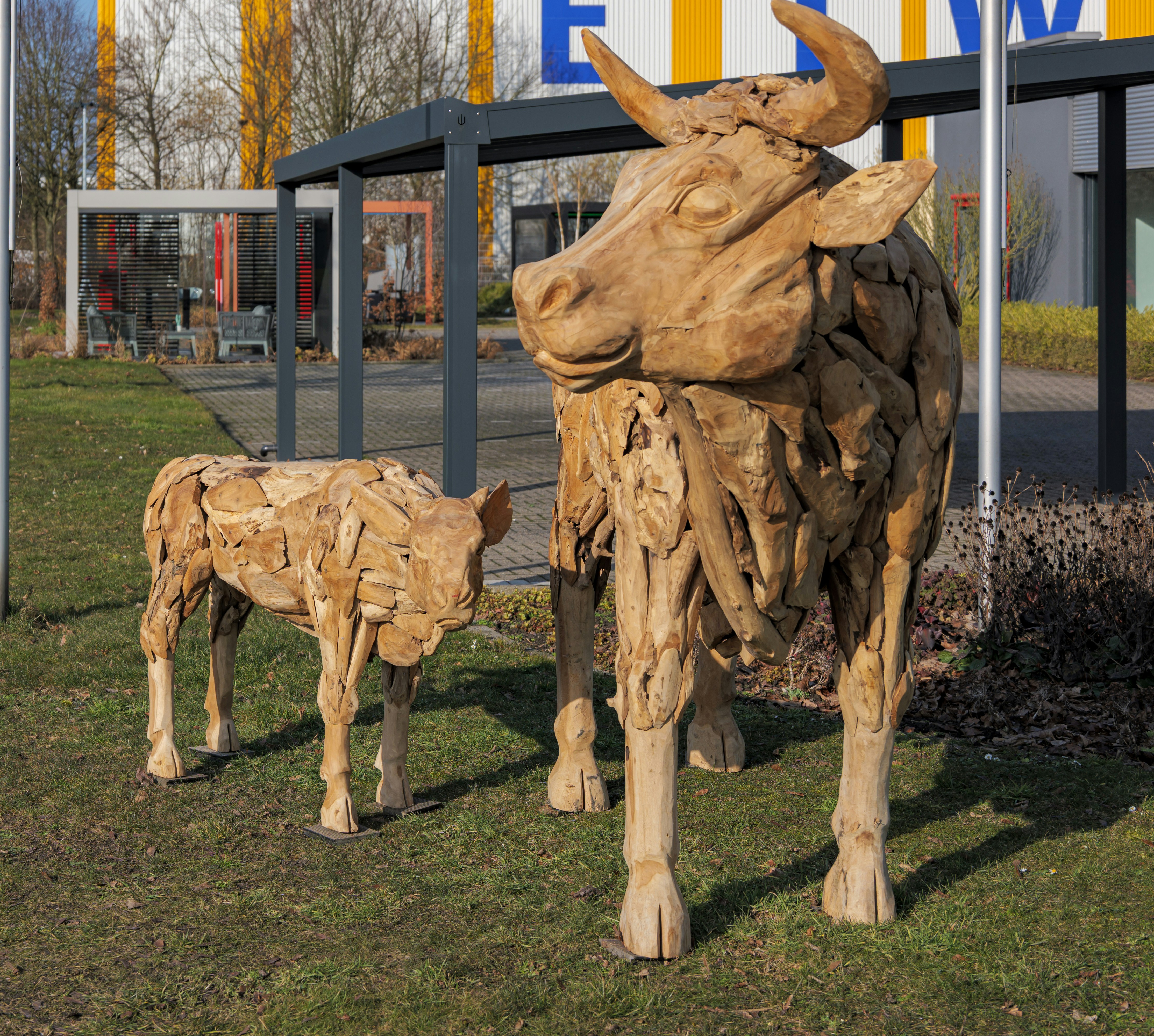 Wooden sculptures of a cow and calf outdoors