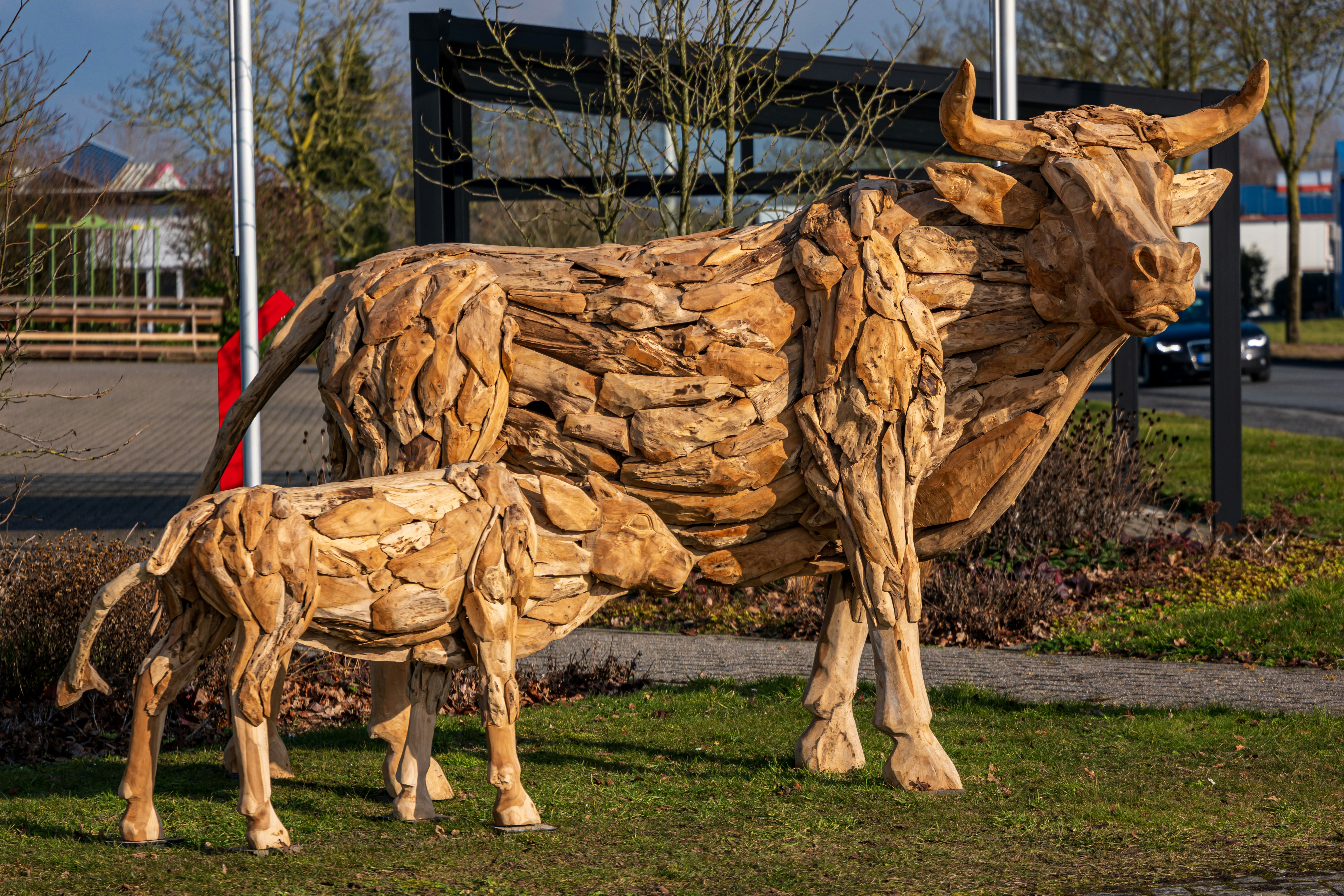 Wooden sculptures of a cow and calf on grass