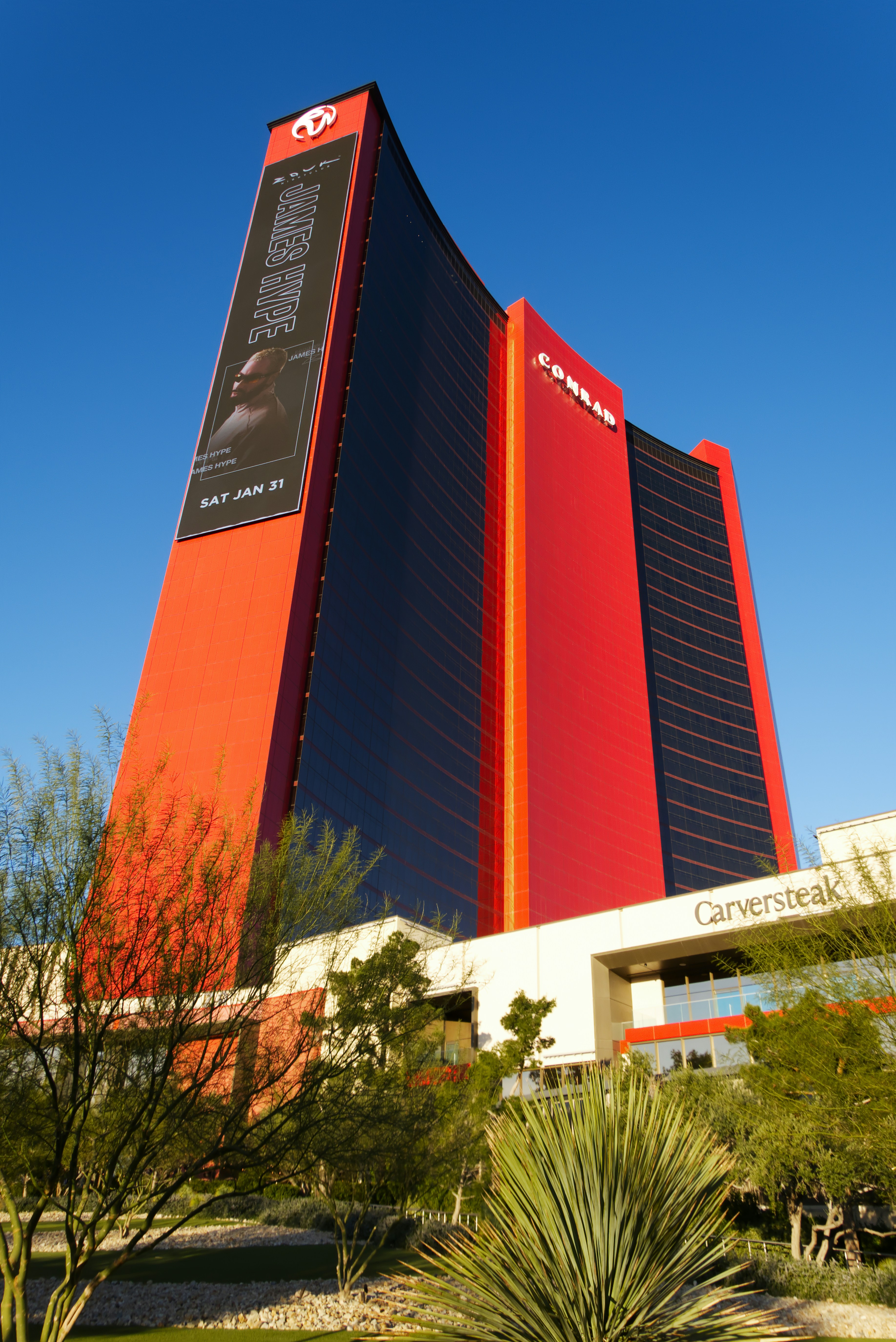 Modern red skyscraper against a clear blue sky