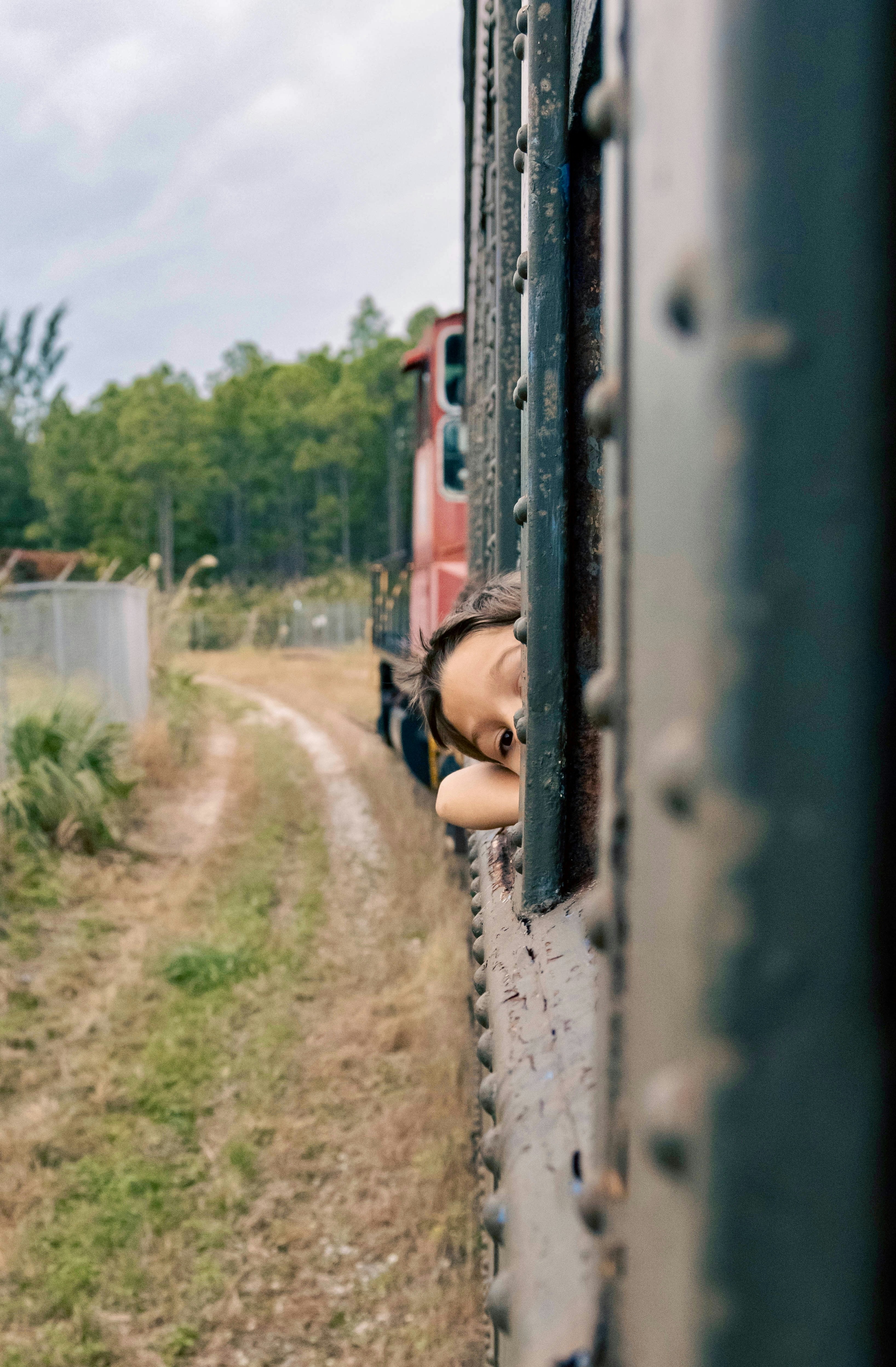 A child sleeps with head out of train window