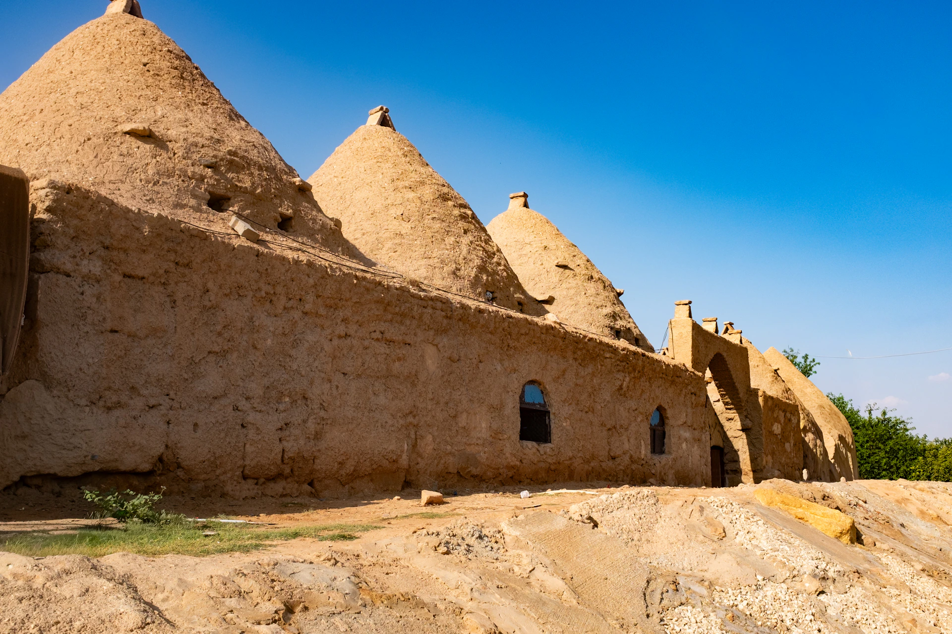 Mud brick conical houses under a clear blue sky