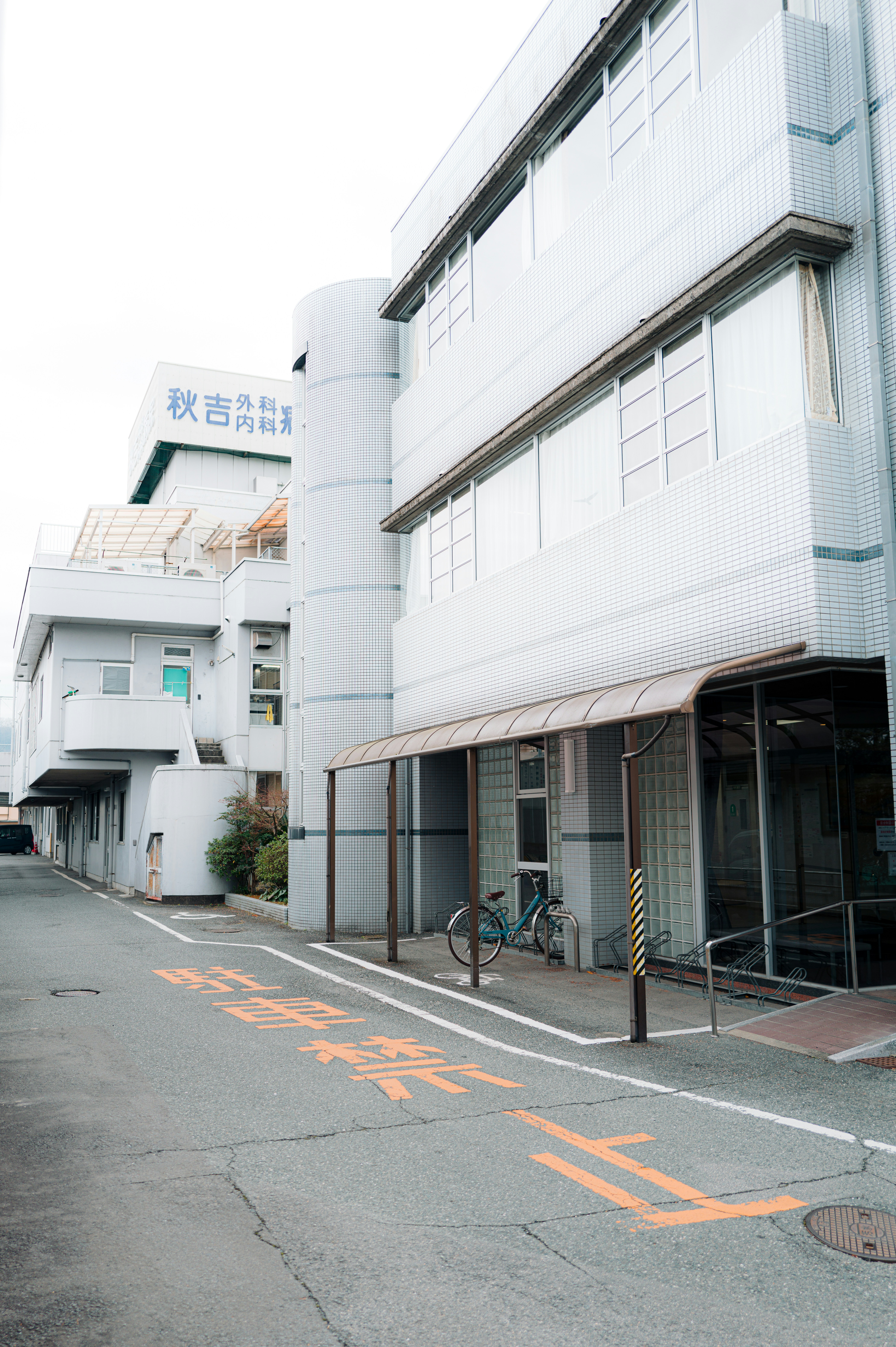 Modern white building with a covered walkway and bicycle.