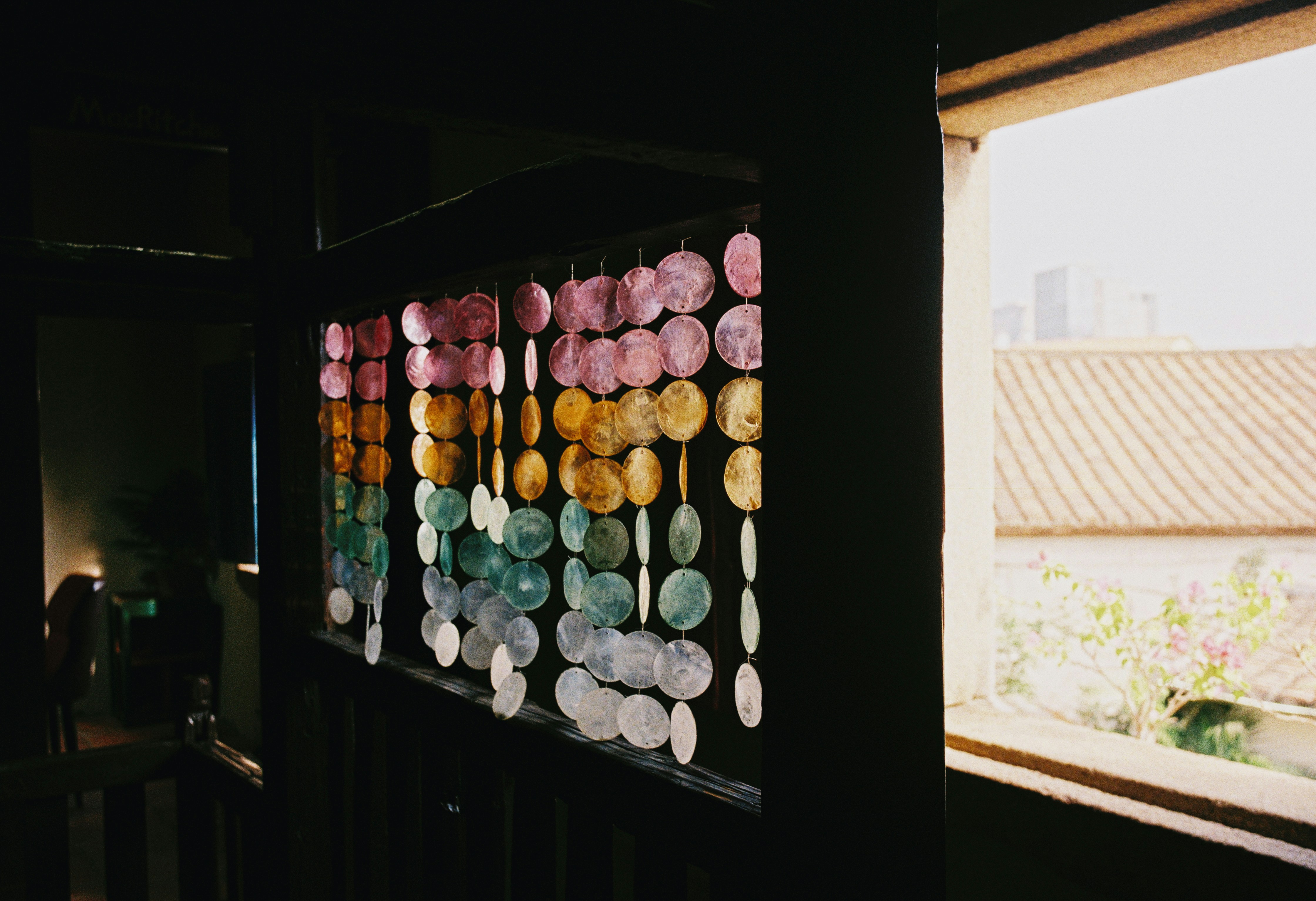 Colorful shell curtain hanging near a window
