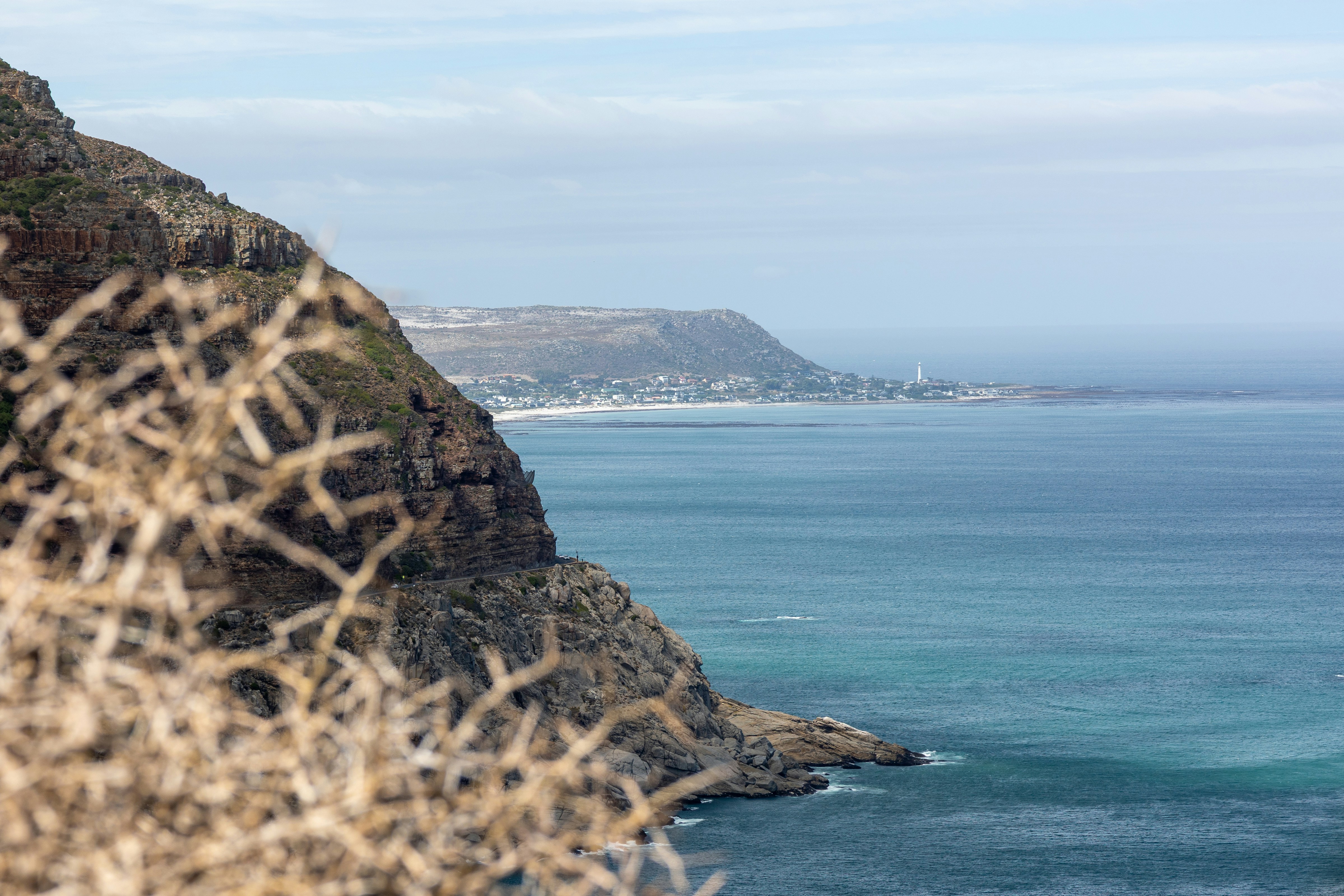 Rugged coastline with ocean and distant town.
