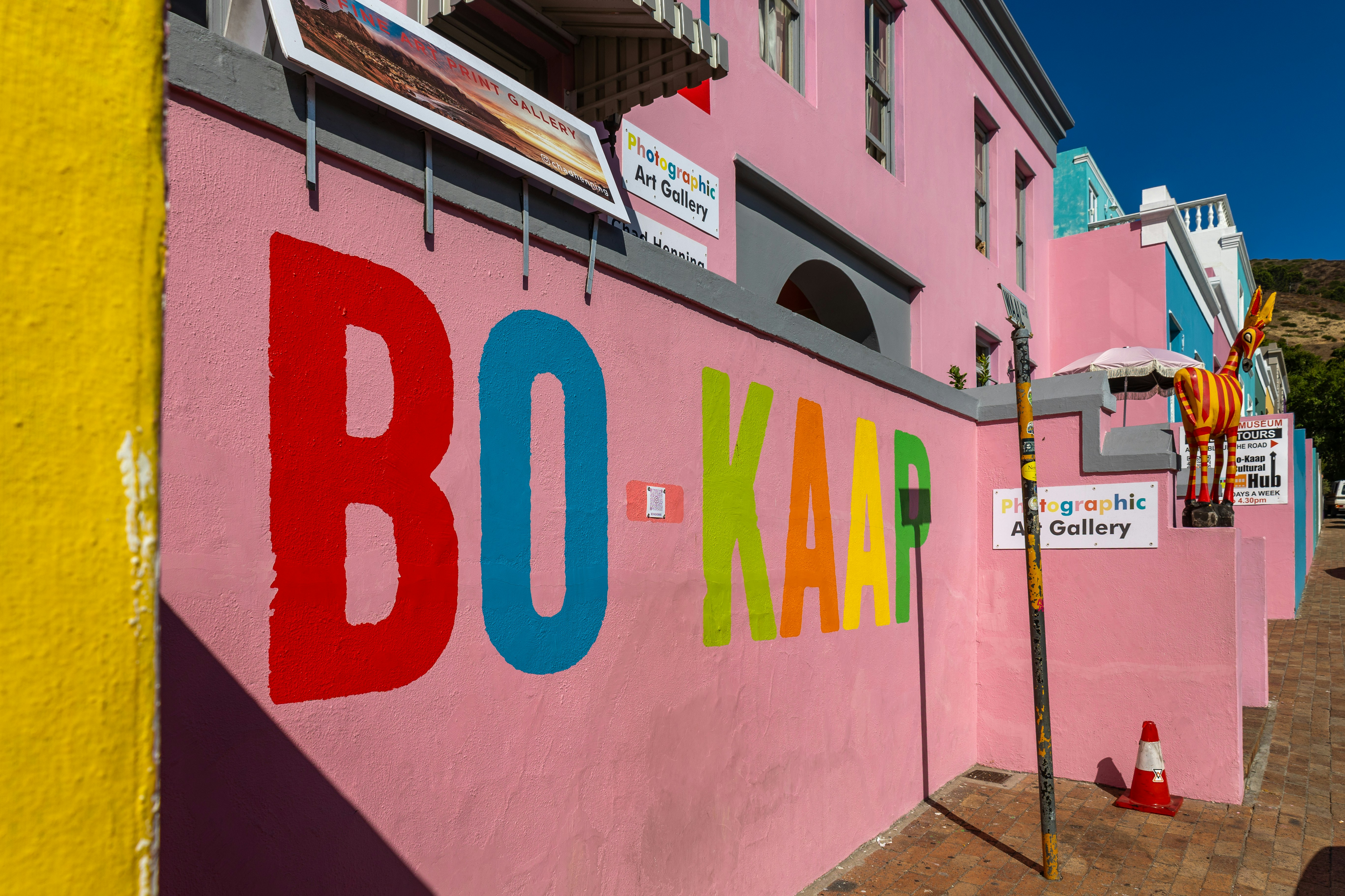 Colorful bo-kaap sign painted on a pink wall