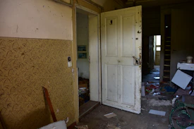 Abandoned room with open doors and debris