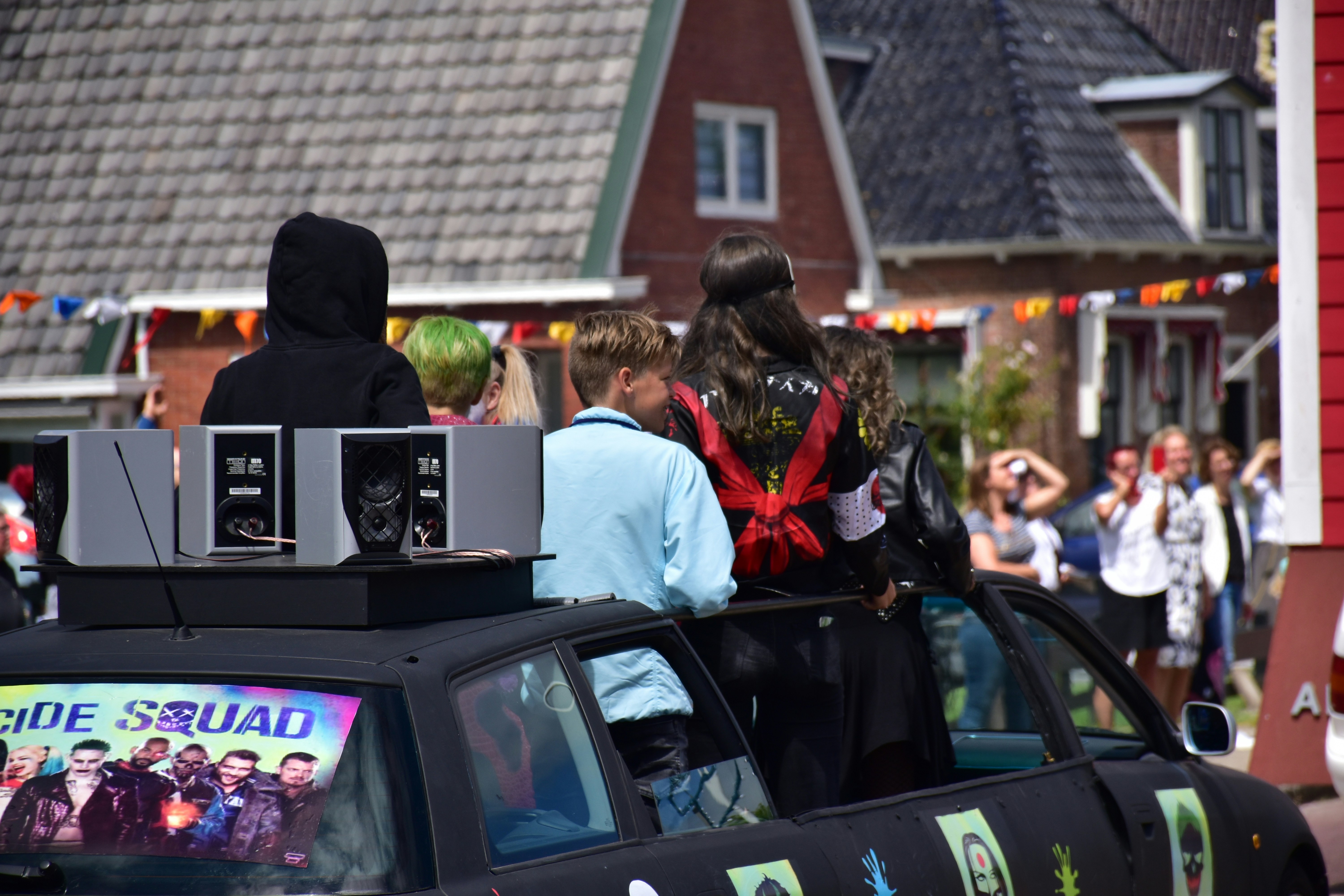 Persone in un'auto decorate per una parata