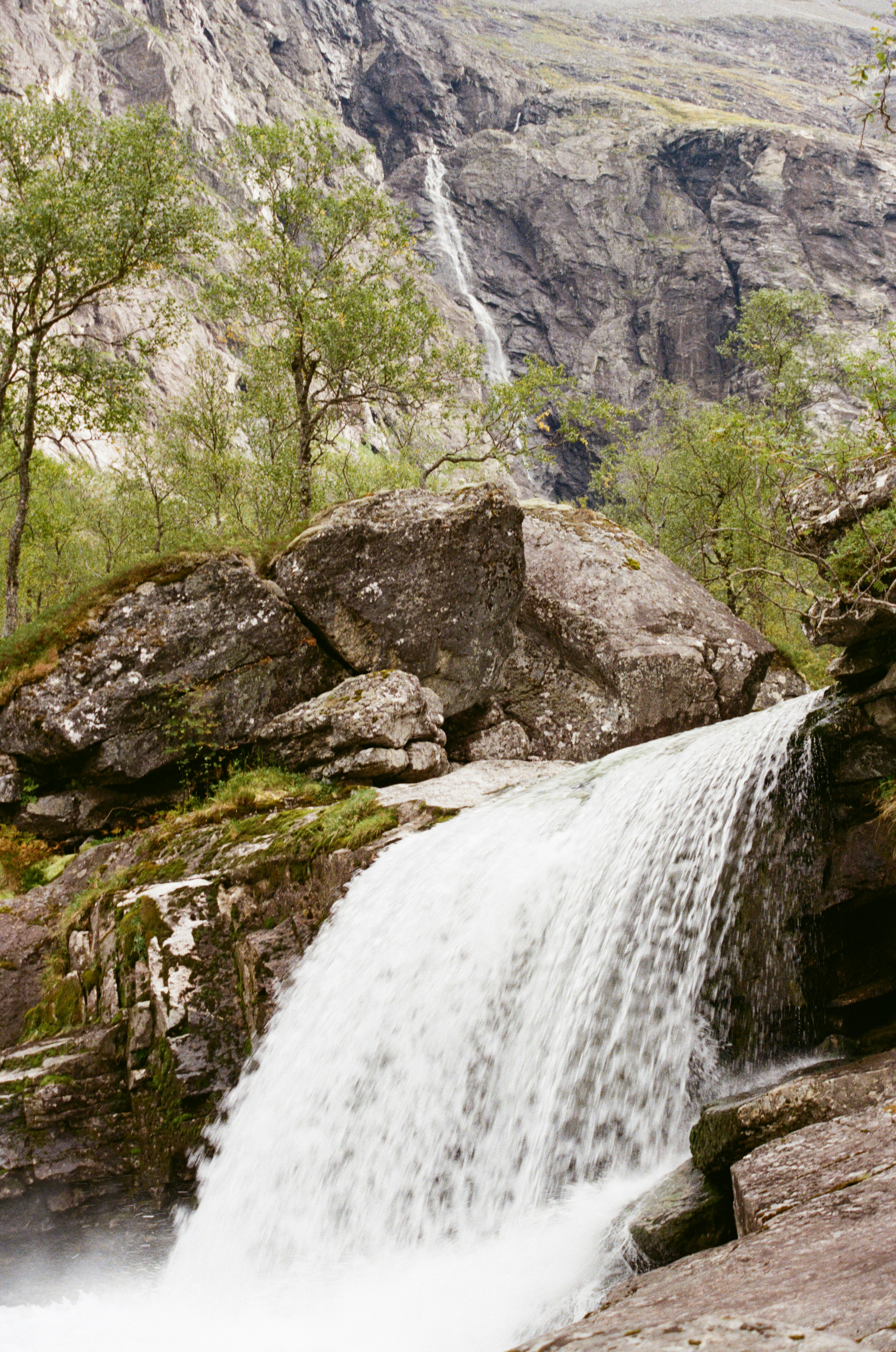 A cascading waterfall flows over rocks in a rocky landscape. photo ...