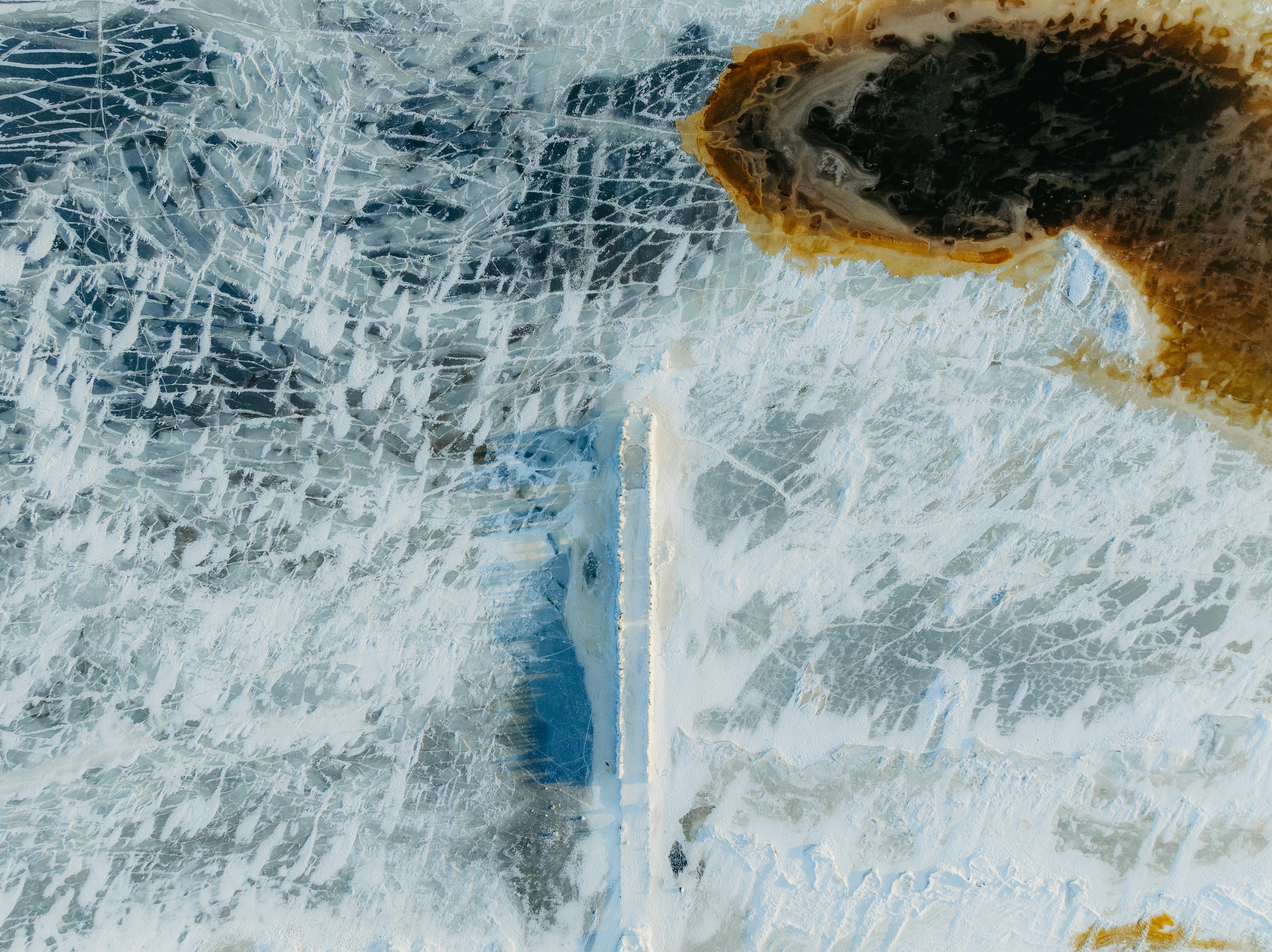 Cracked ice with brown earth texture from above