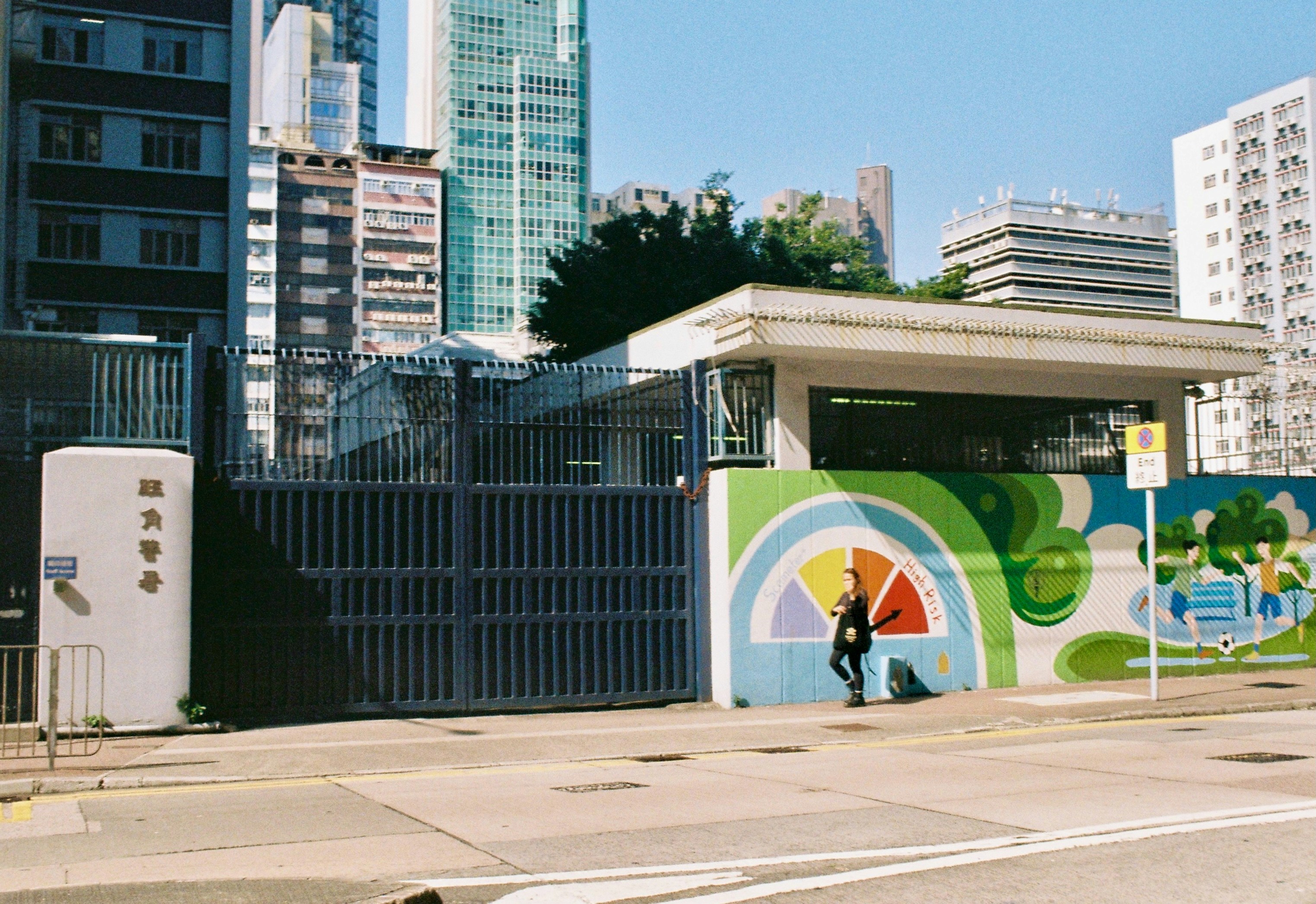 Person walks by a colorful mural on a building wall.