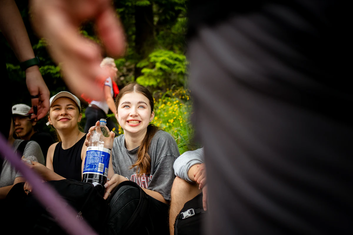 Freundinnen mit Wasserflasche draußen im Grünen als Symbol für rauchfreie Sommermomente