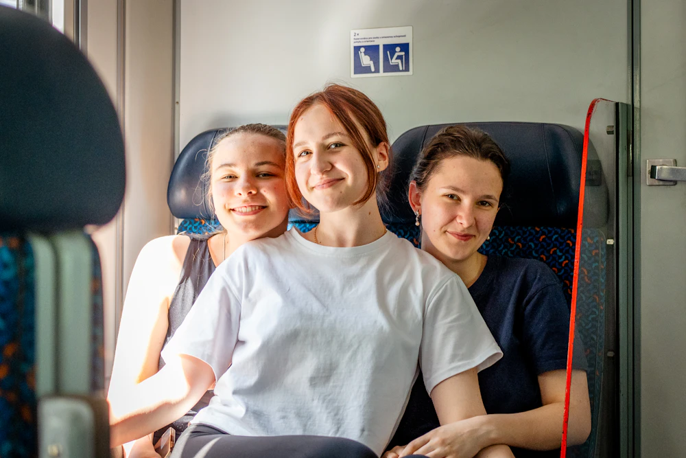 Friends smiling together on a clean, comfortable train