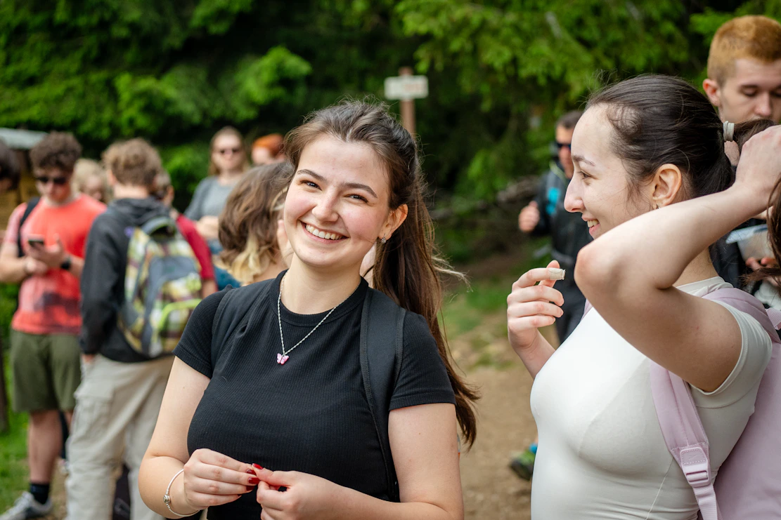 Young woman smiling with friends on a nature trail