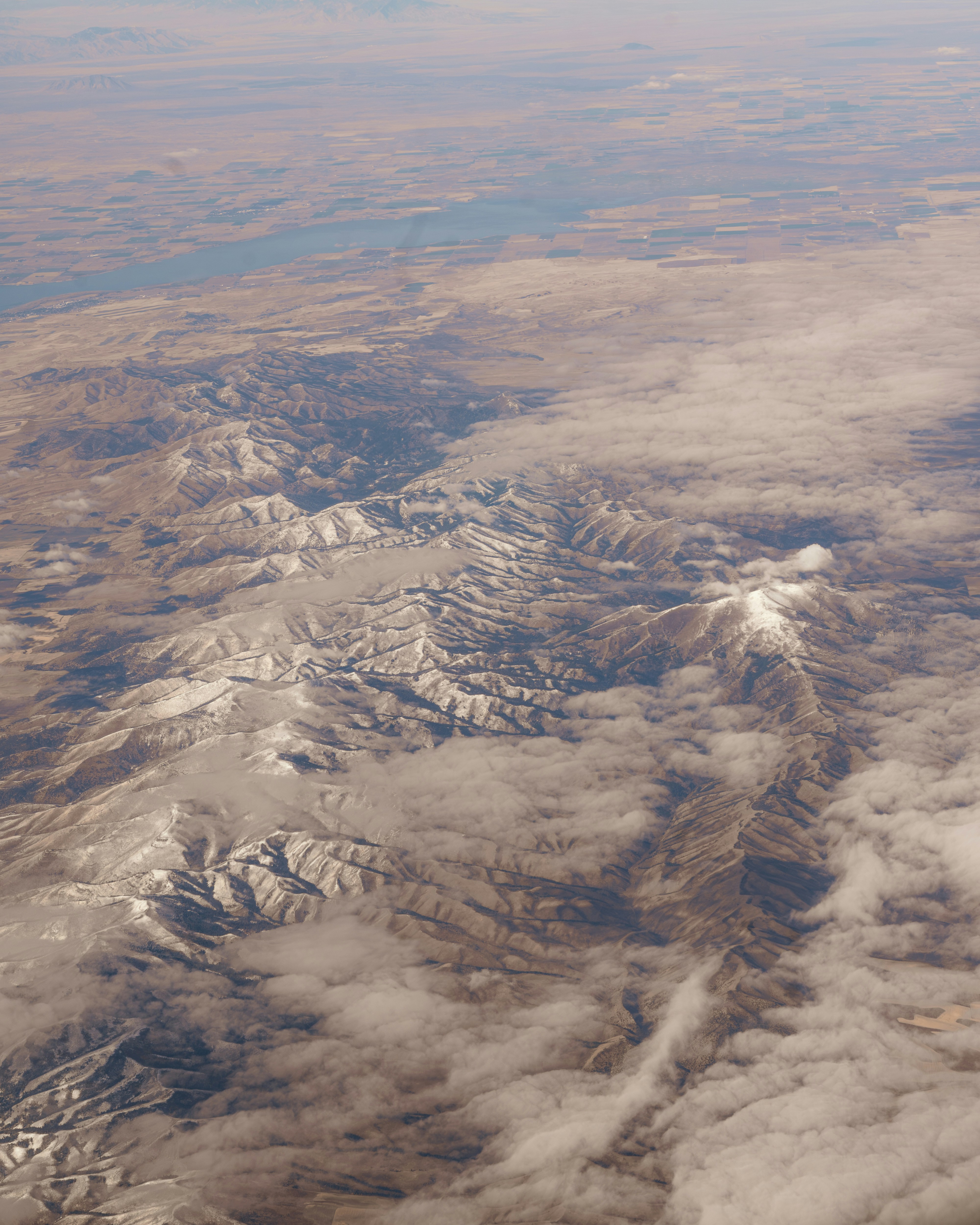 Snow-capped mountains with clouds and a river.