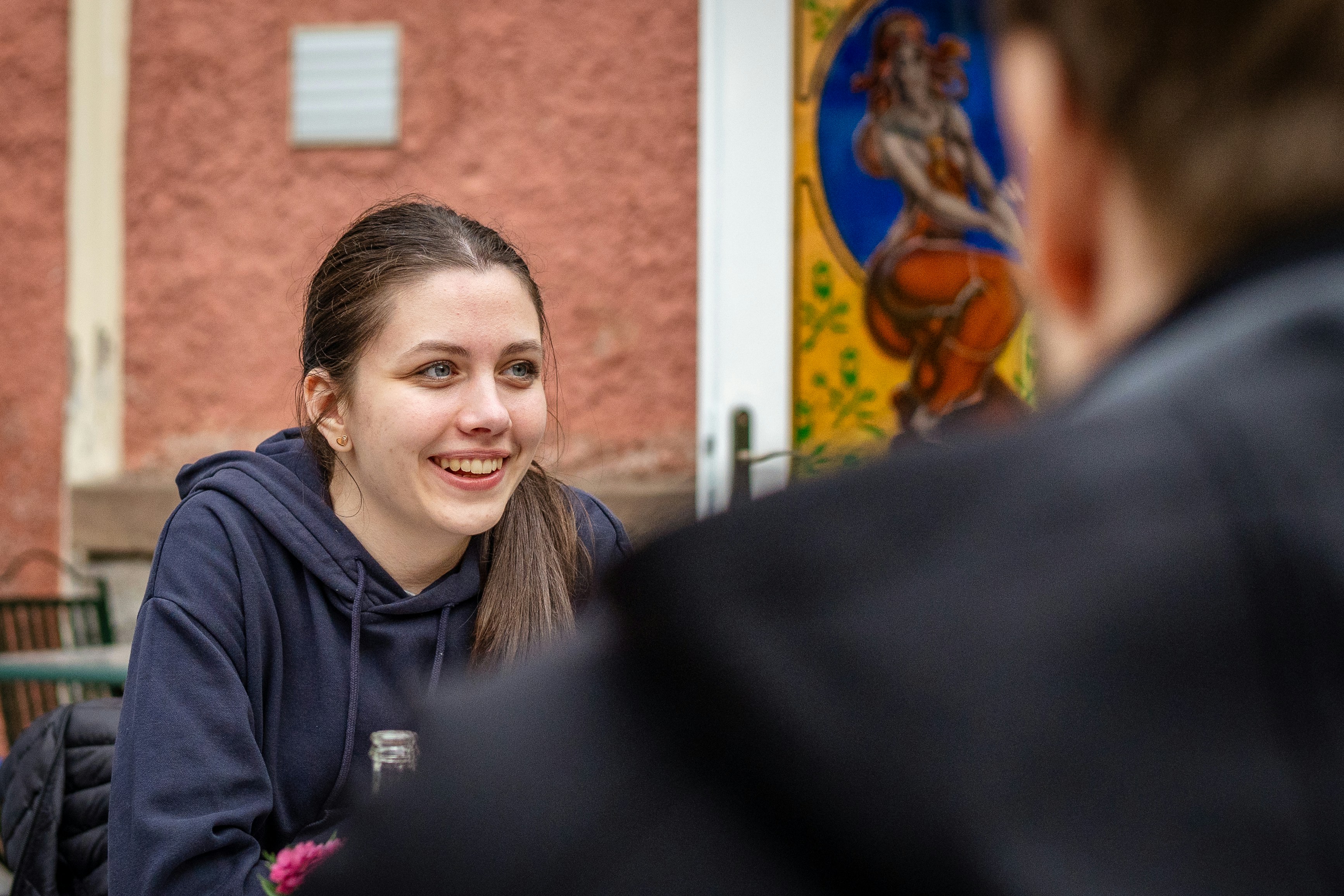Young woman smiling while talking to someone