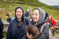 Two young women smiling outdoors with friends