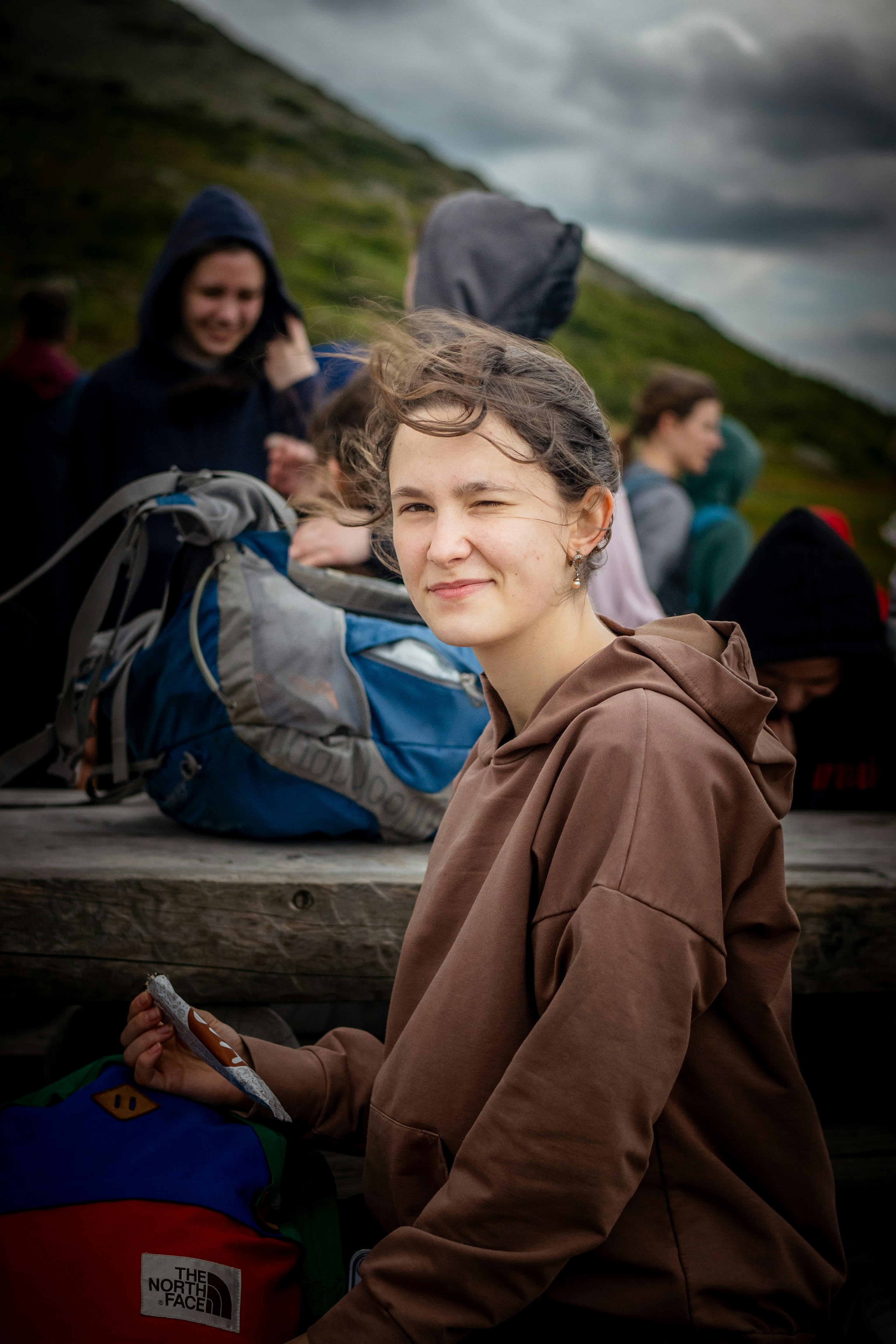 Young woman with brown hoodie smiling outdoors