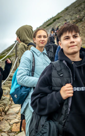 Young people hiking up a rocky mountain path