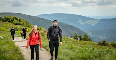 People hiking on a mountain trail with scenic views