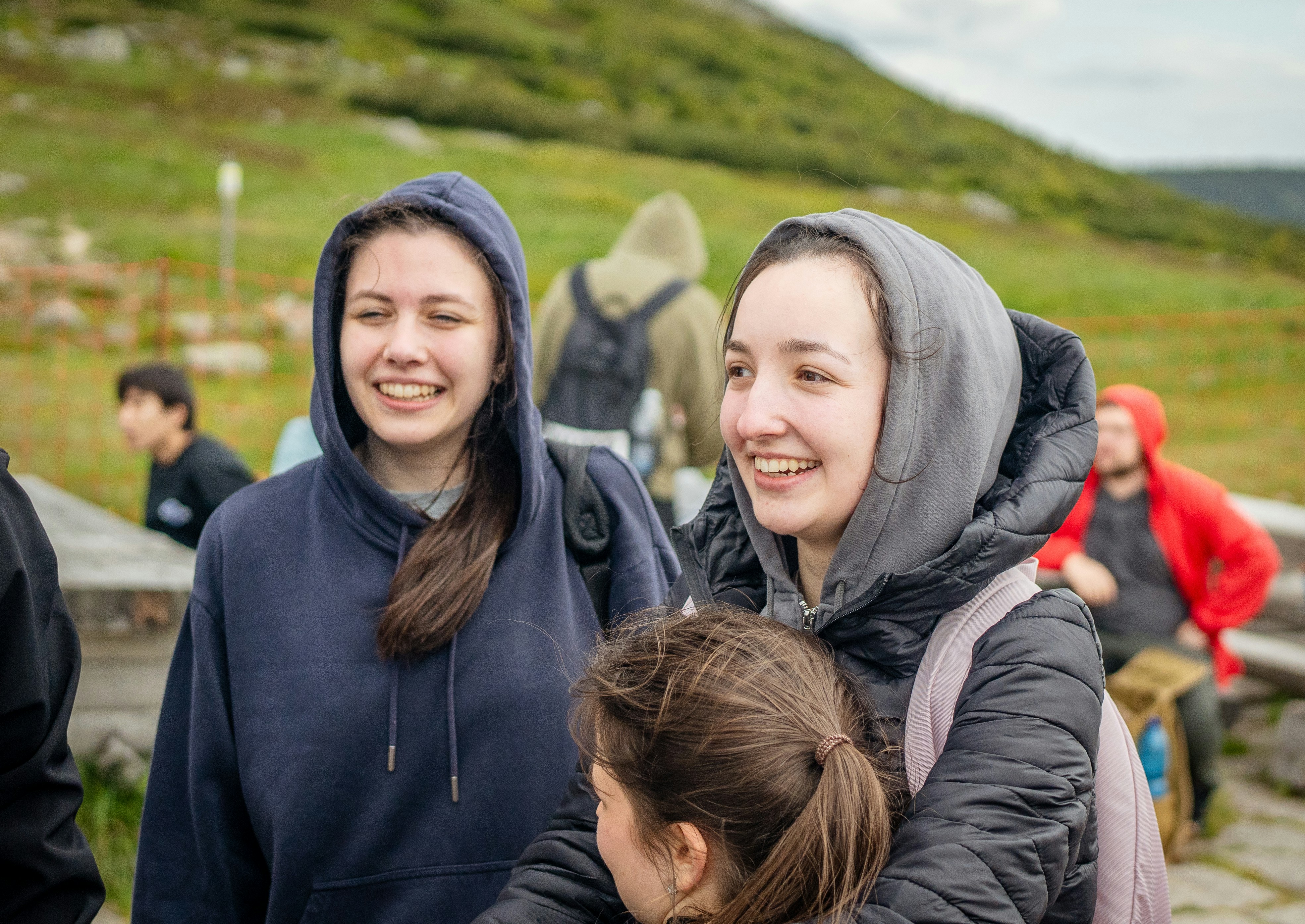 Two smiling young women in hoodies outdoors