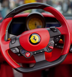 Close-up of a red and black ferrari steering wheel.