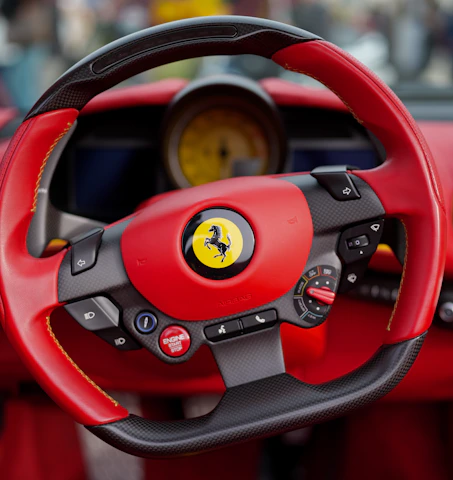 Close-up of a red and black ferrari steering wheel.