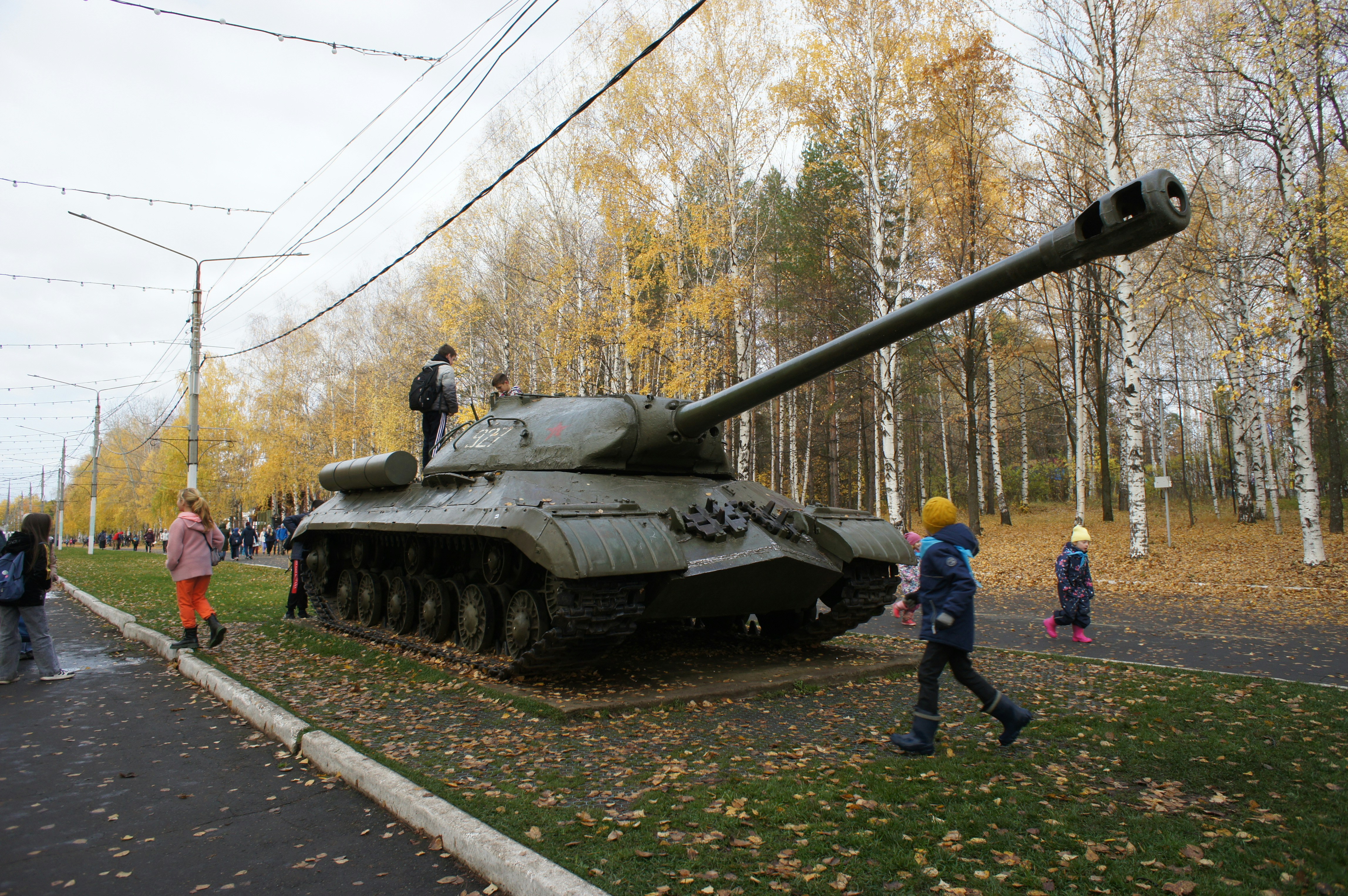 People gather around a large military tank on display
