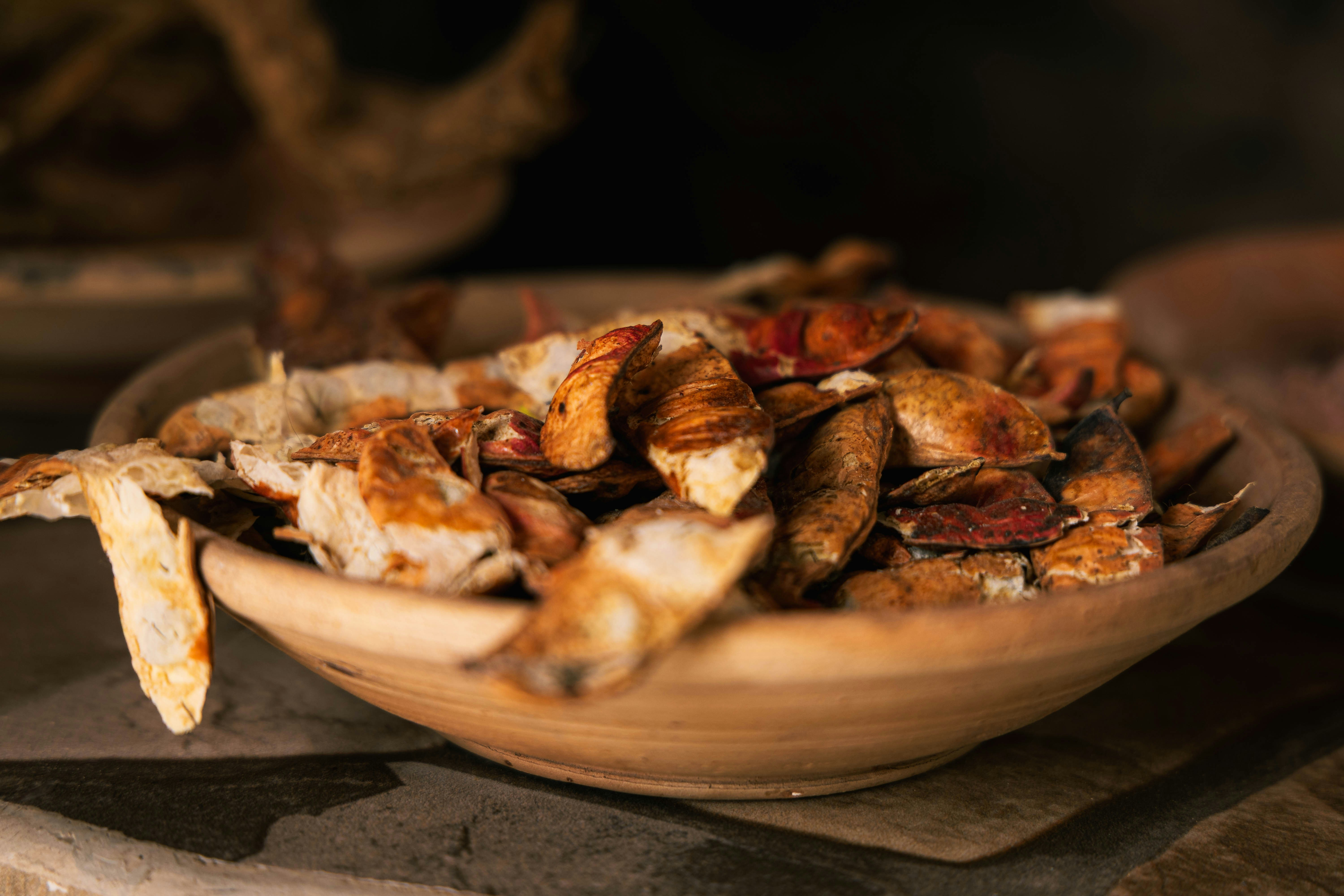 A wooden bowl filled with dried mushrooms