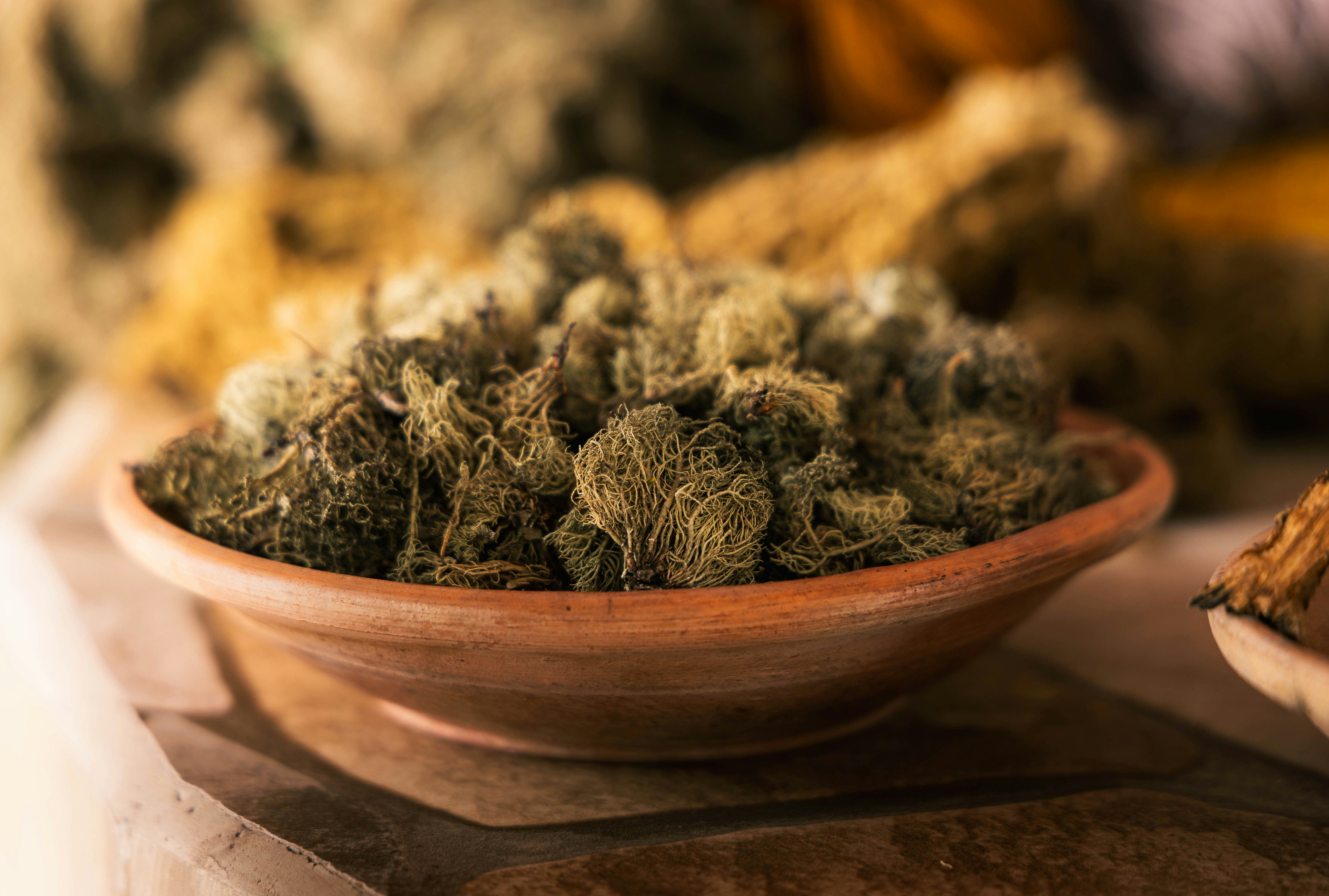 A close-up of dried herbs in a rustic bowl