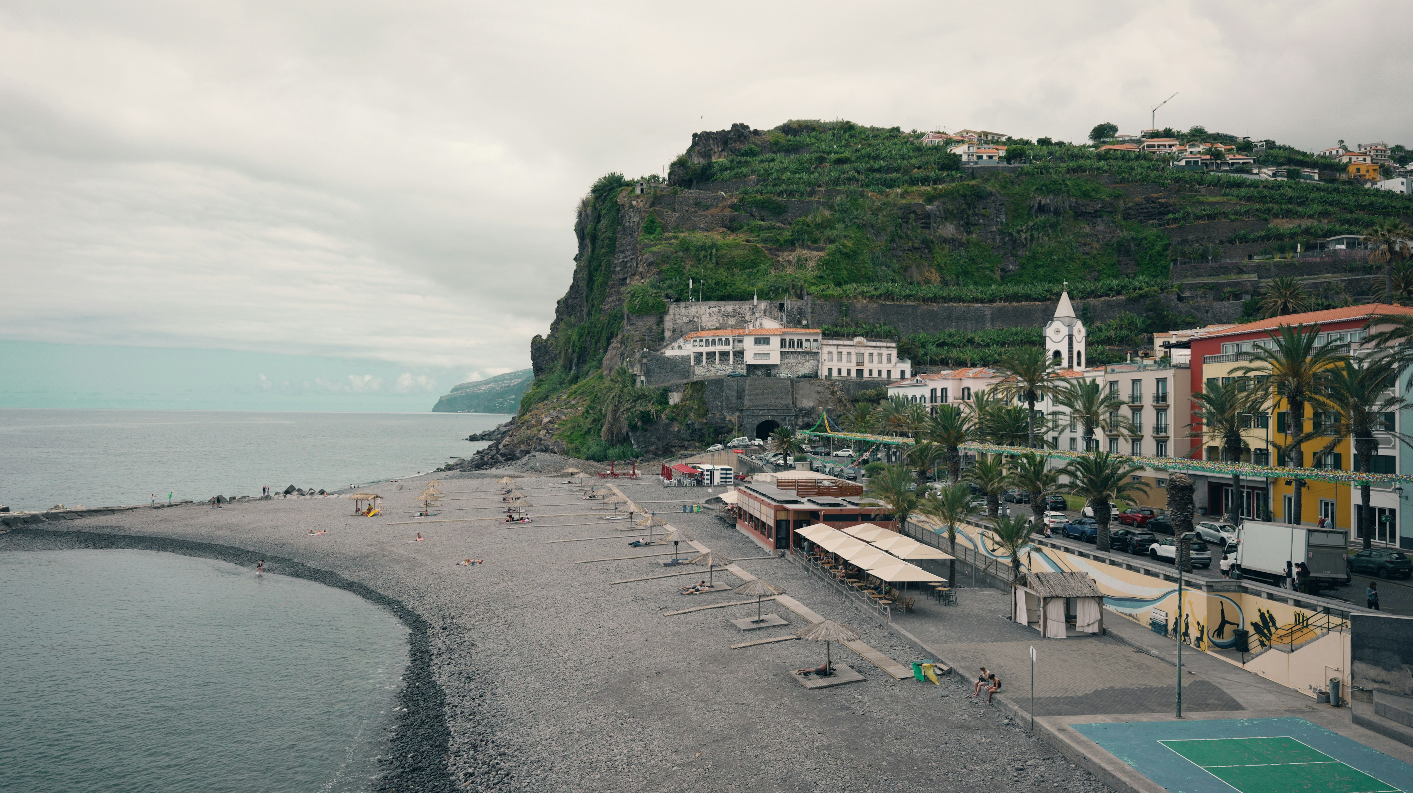 Coastal town with beach and steep green cliffs