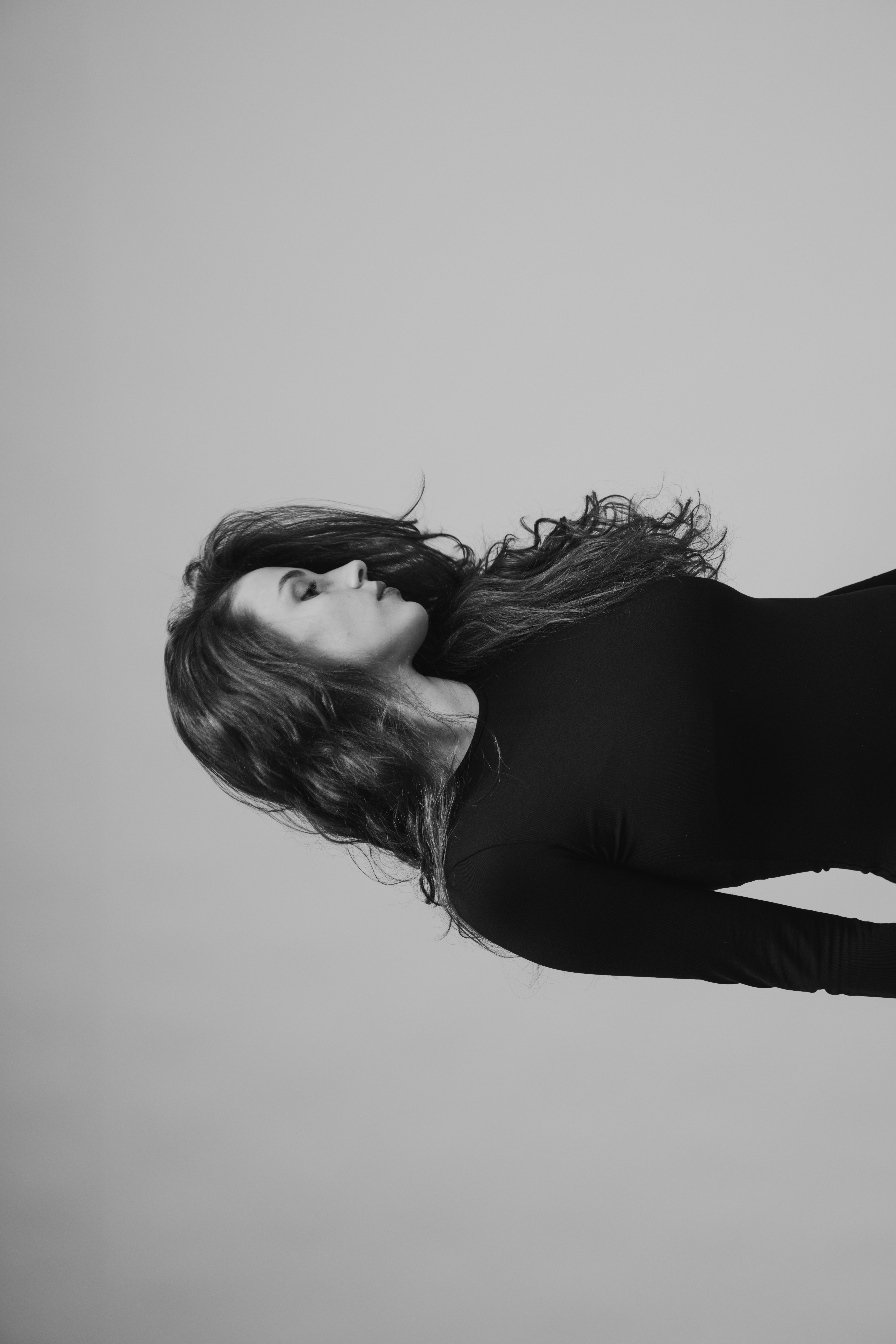 A woman with long, wavy hair in a black top.