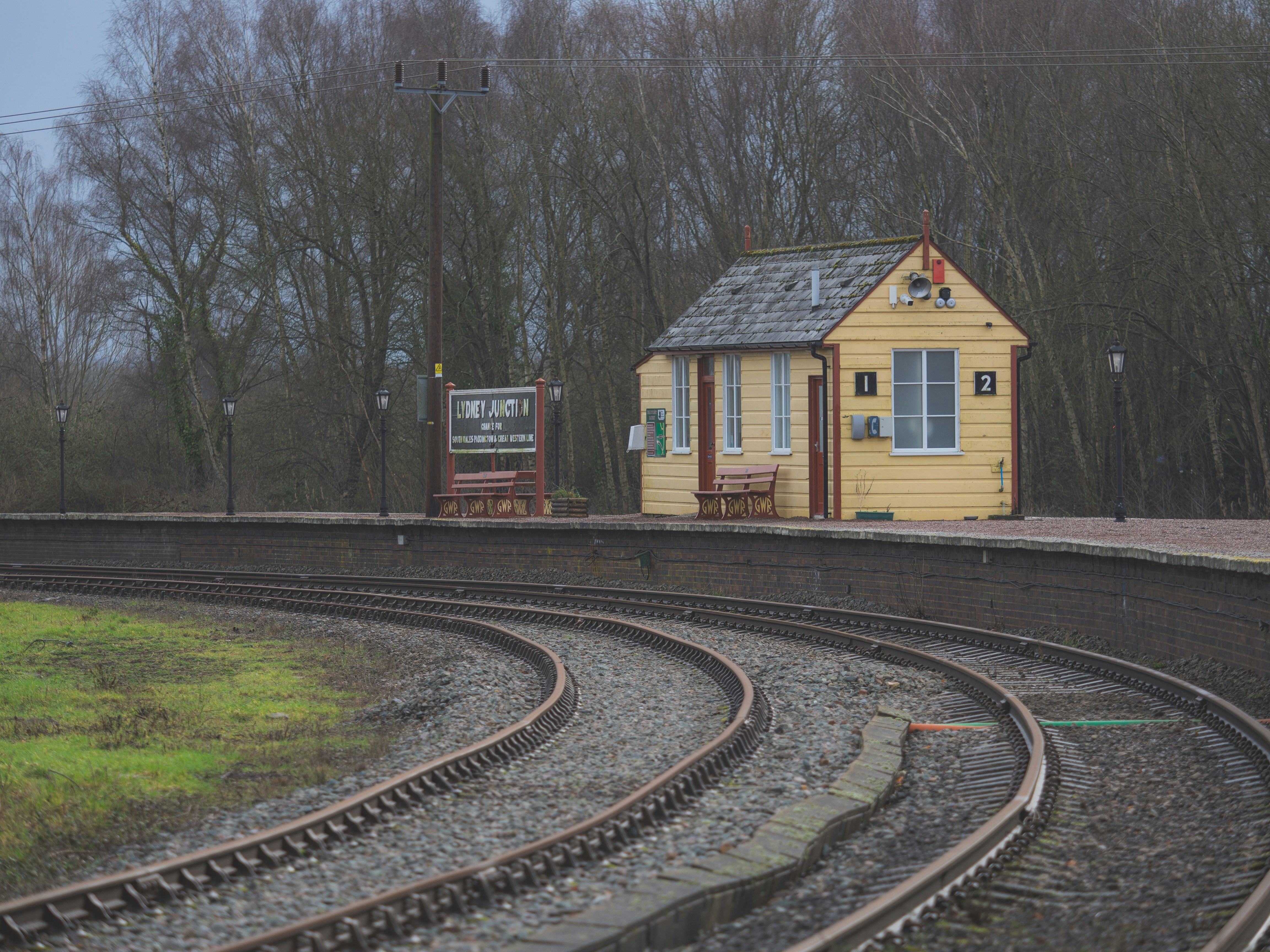 A small yellow building on a train platform.
