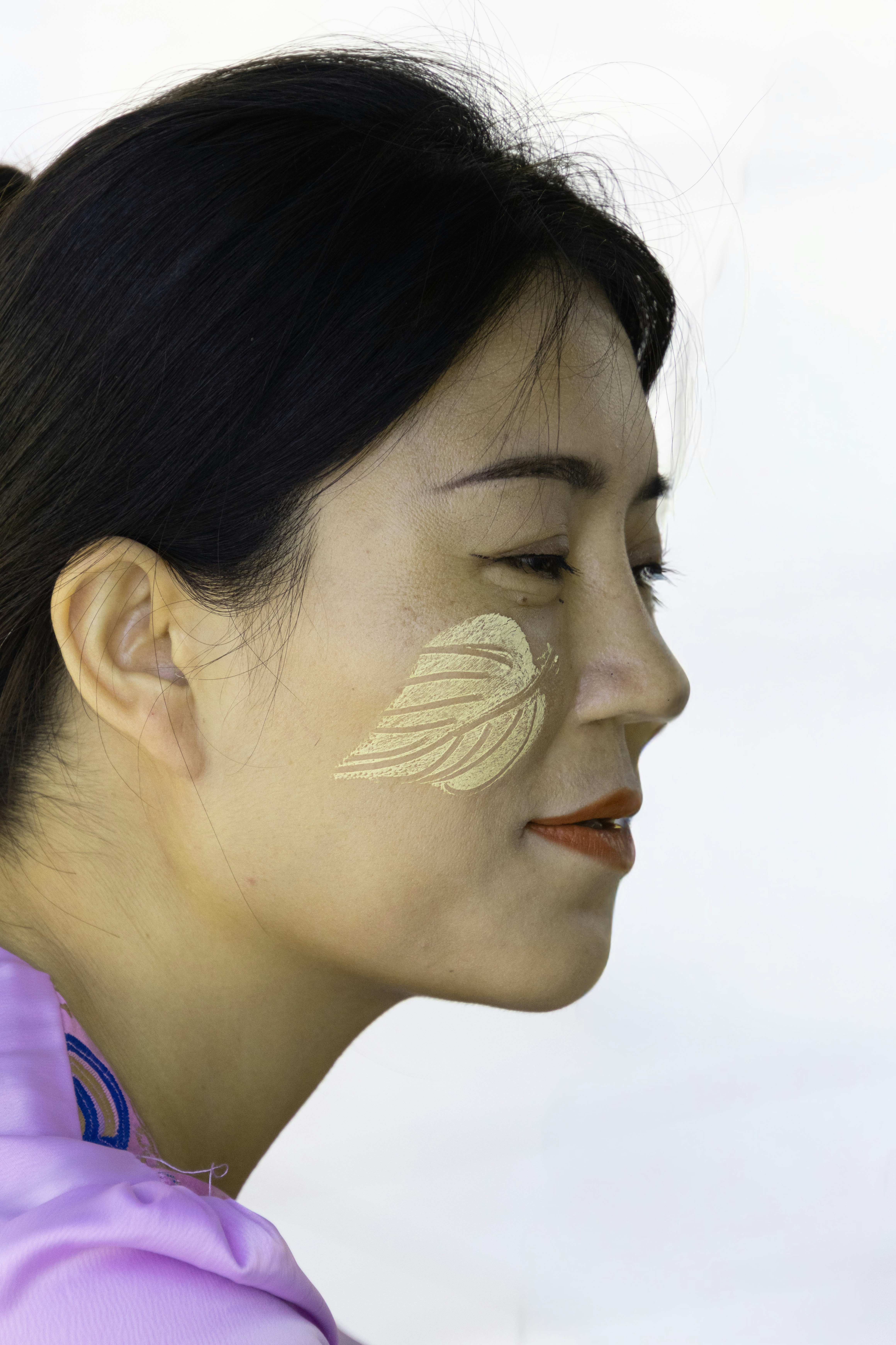 Frau mit Blattmuster auf der Wange