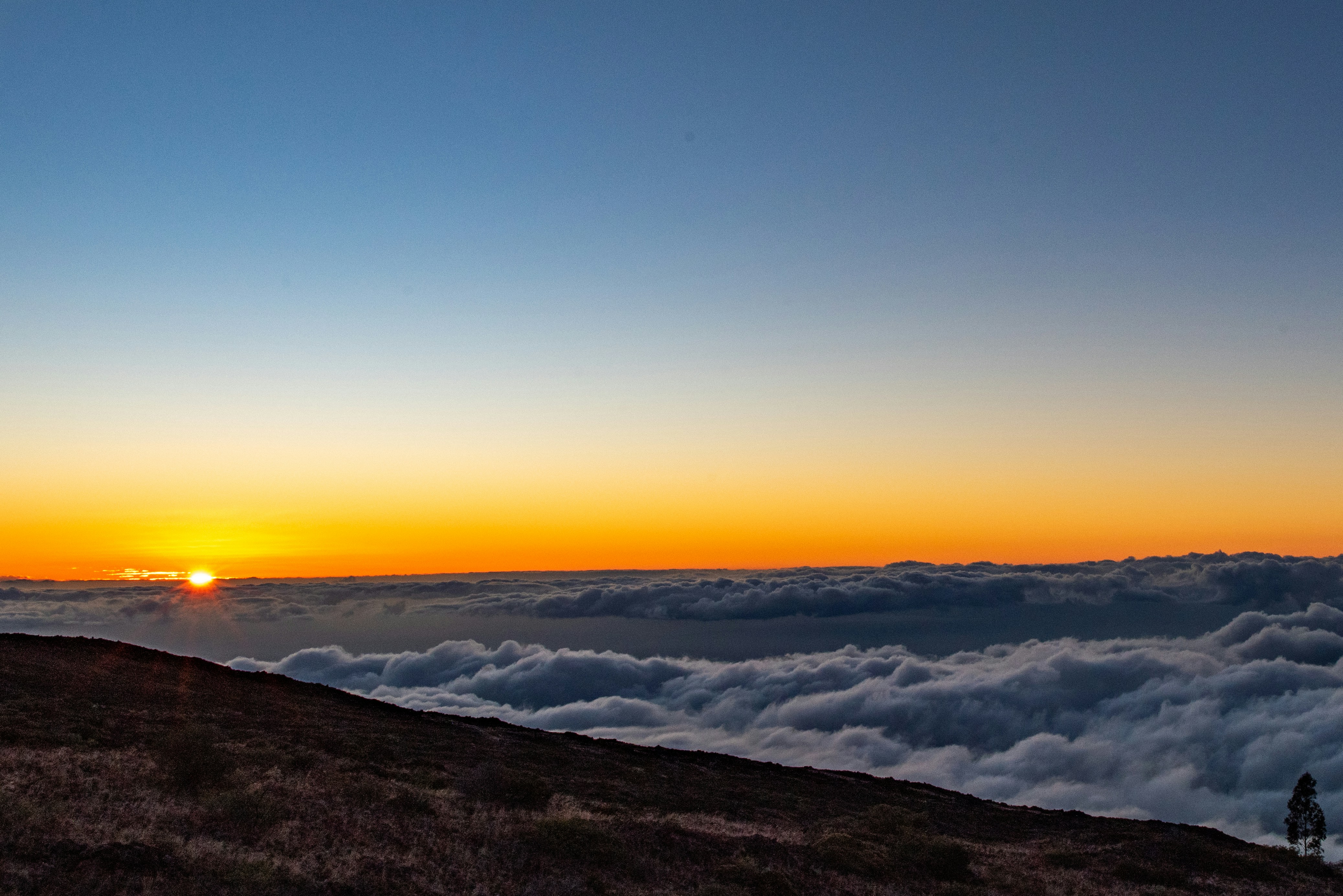 Lever du soleil au-dessus d’une mer de nuages depuis le sommet de la montagne