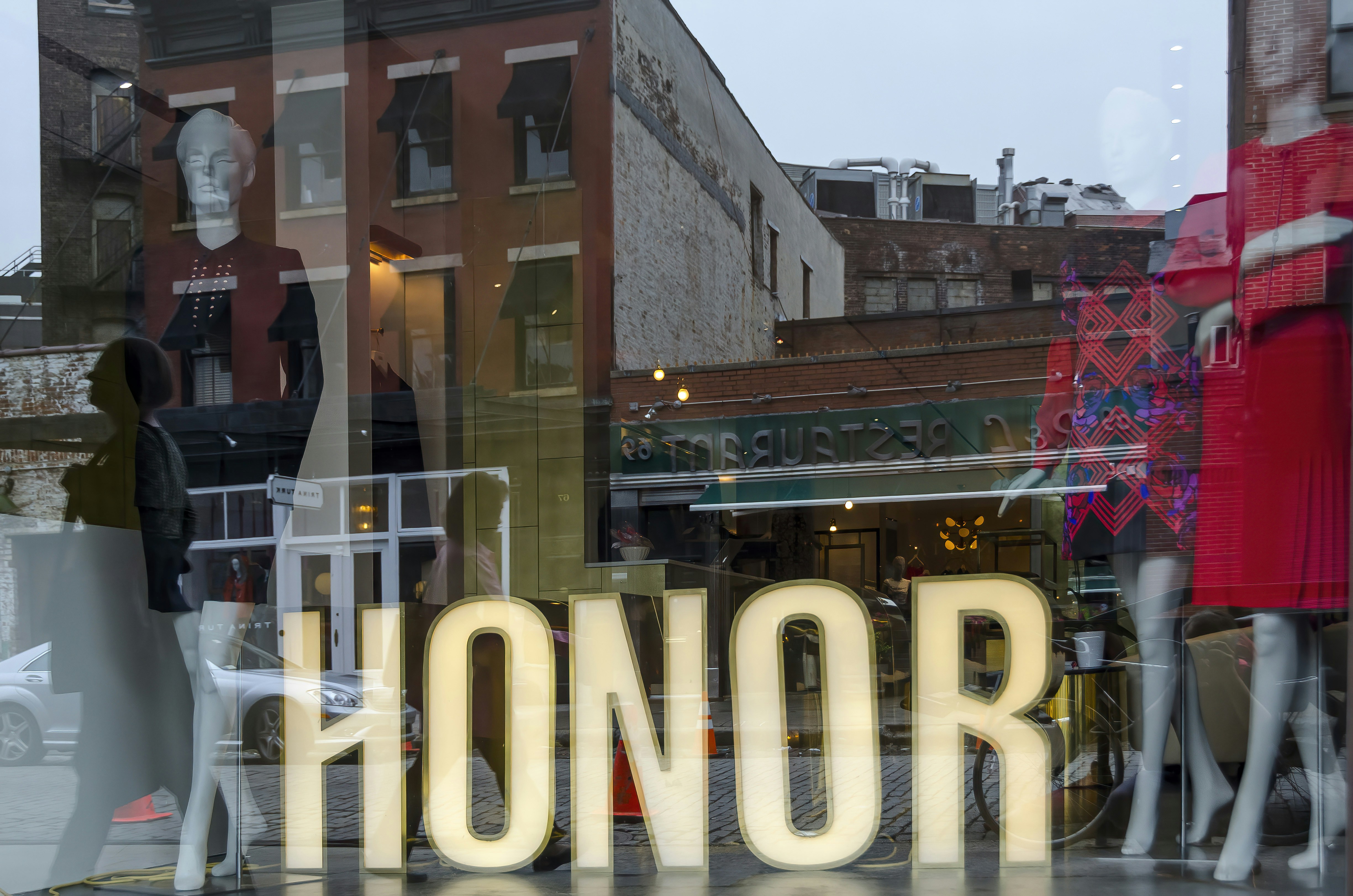Store window display with "honor" text and mannequins.