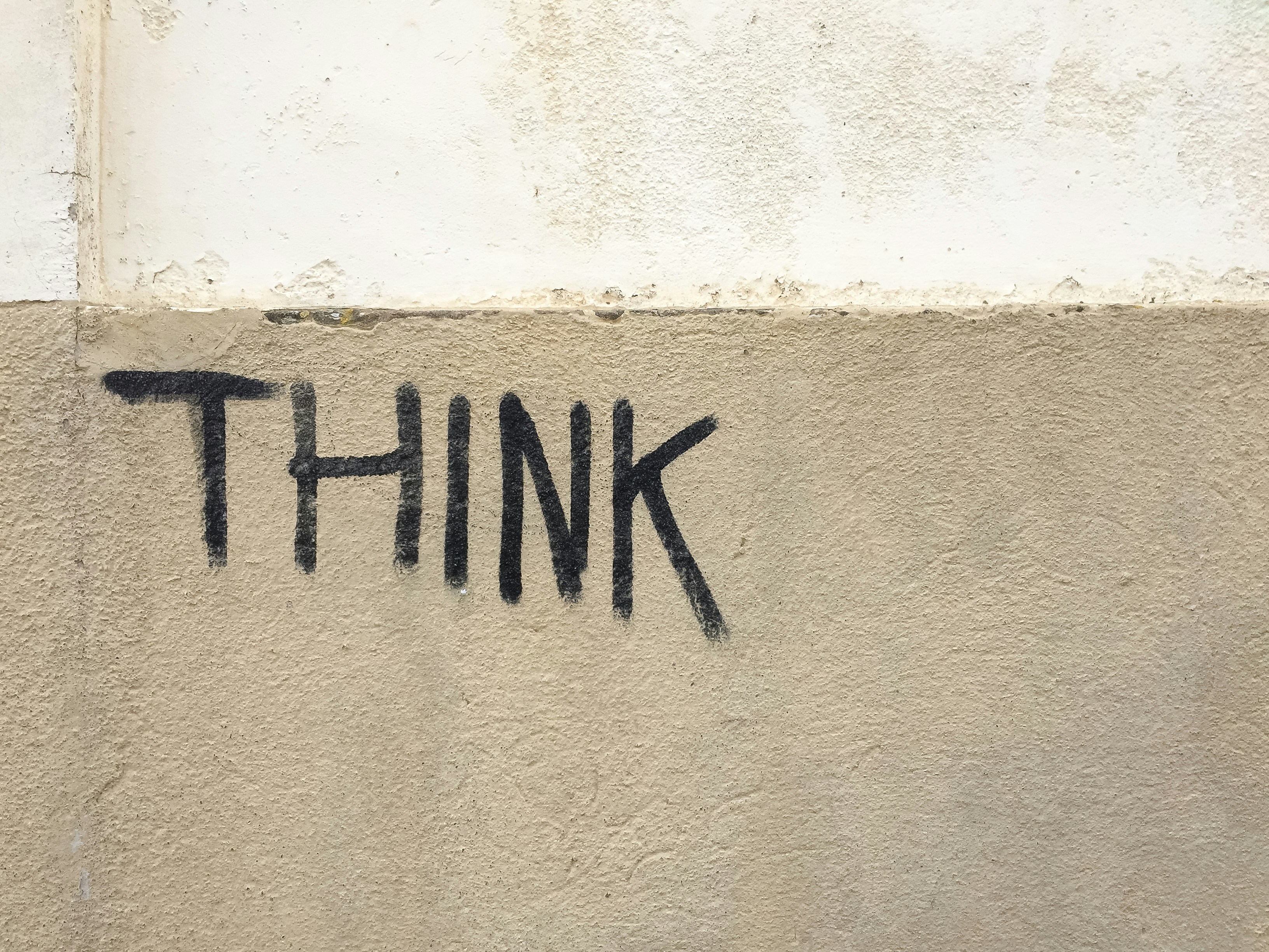 The word think spray painted on a wall