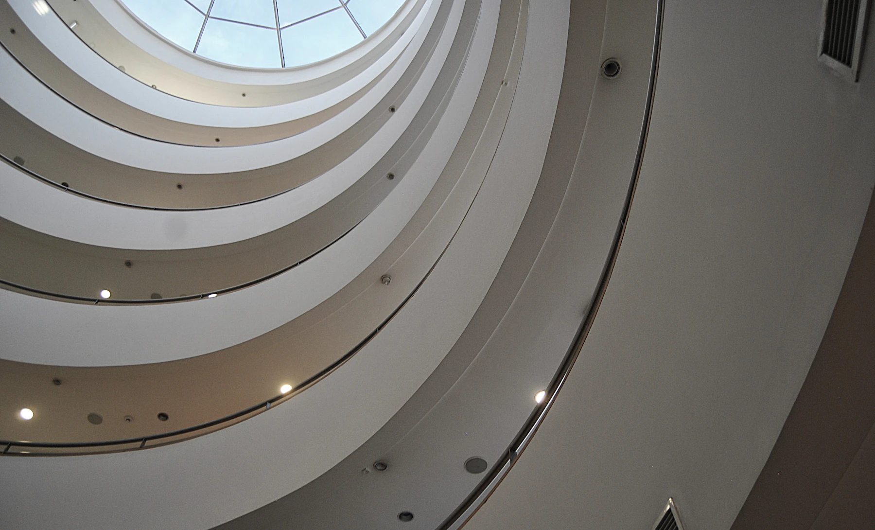 Looking up through the glass dome of a modern spiral atrium