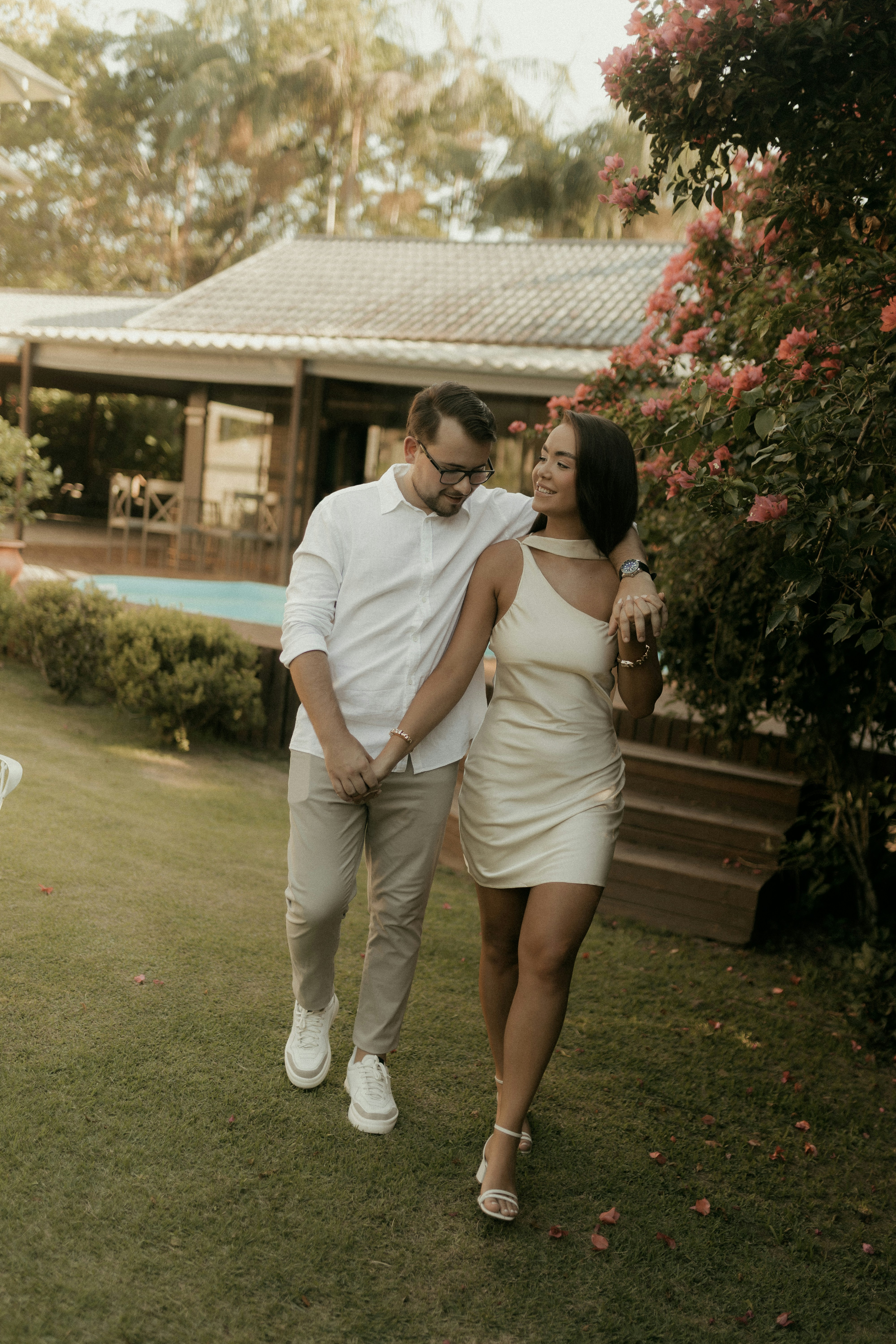 Couple walking hand-in-hand in a garden