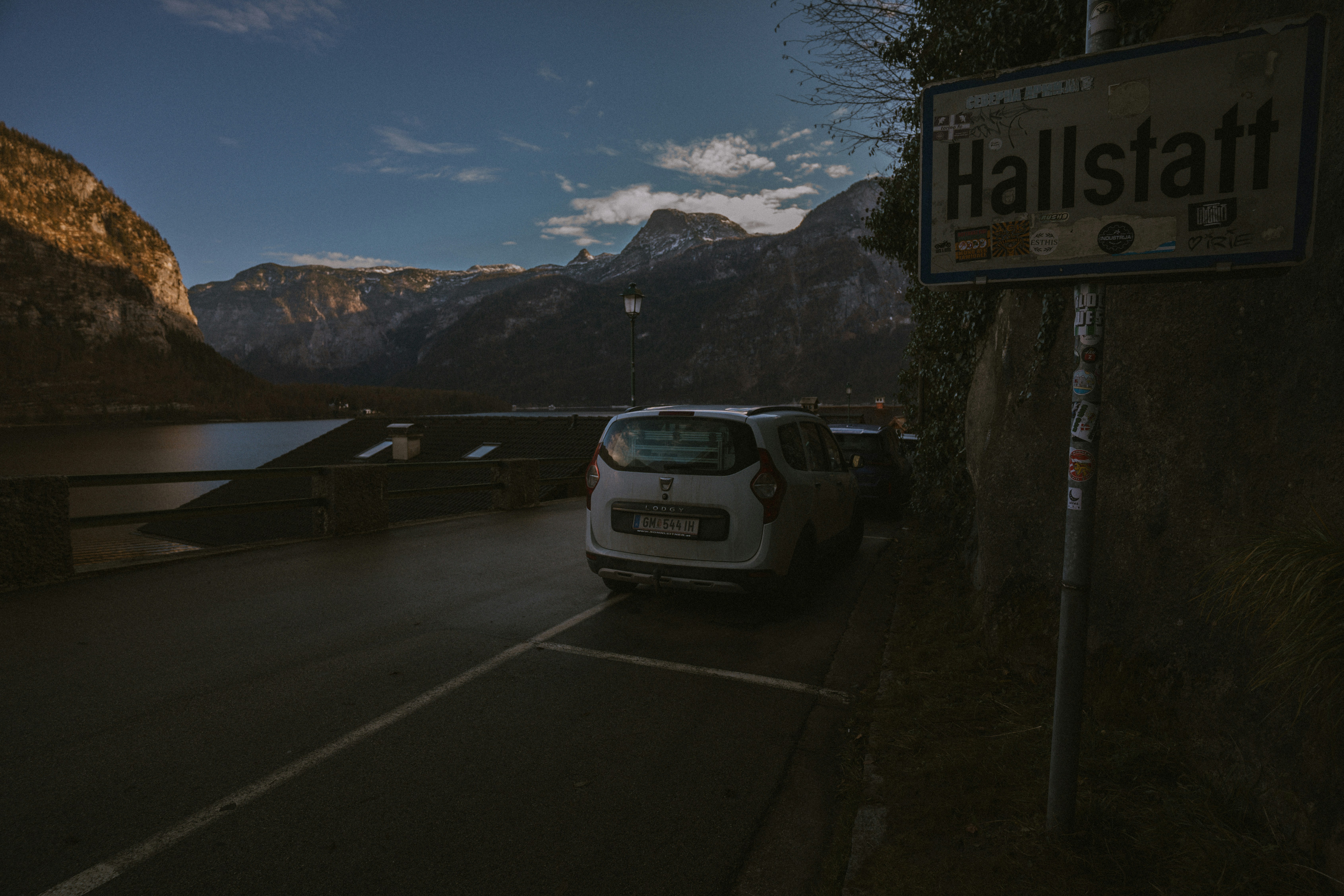 Hallstatt sign with car and mountain lake view