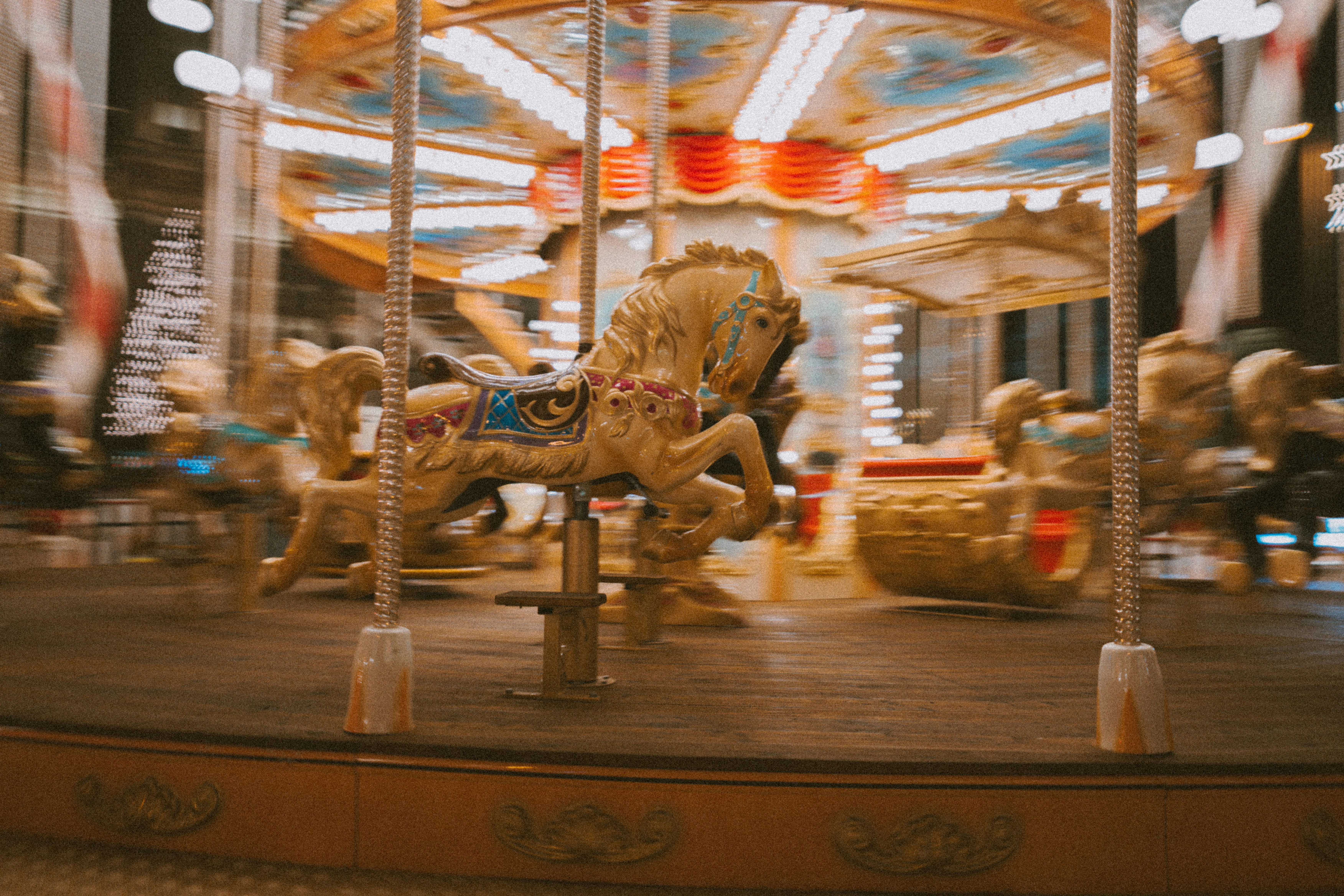 A blurred carousel with golden horses in motion