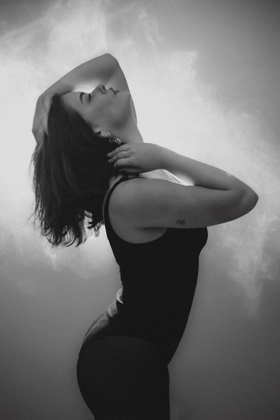 Woman in black tank top with head tilted back