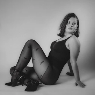 Woman in patterned tights and bodysuit poses gracefully