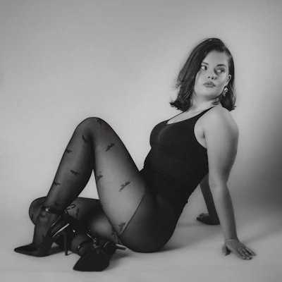Woman in patterned tights and bodysuit poses gracefully