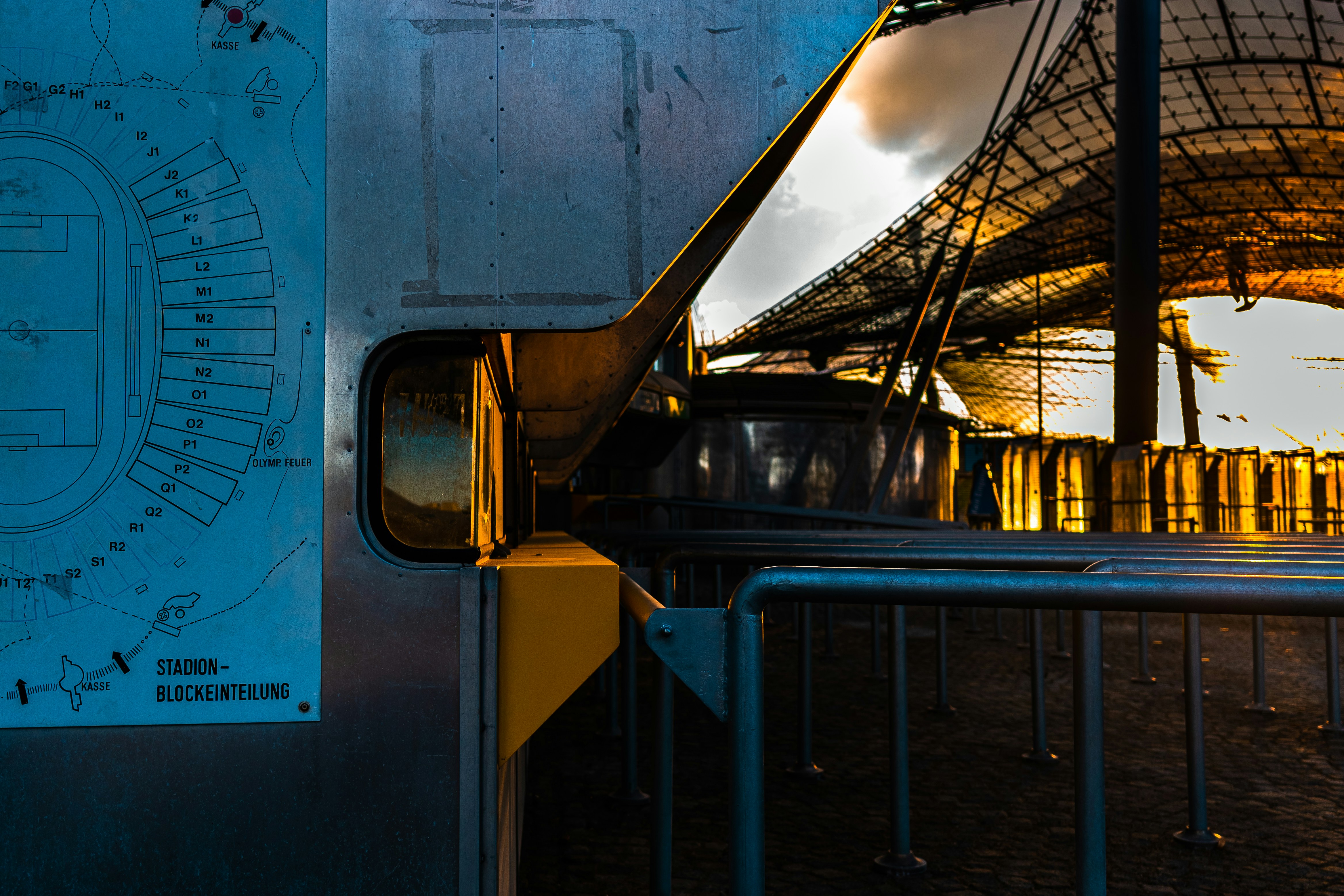 Modern train station entrance with reflections at sunset