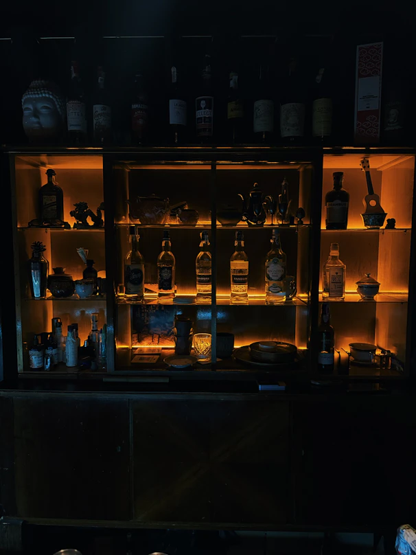 Bottles of liquor displayed on illuminated shelves