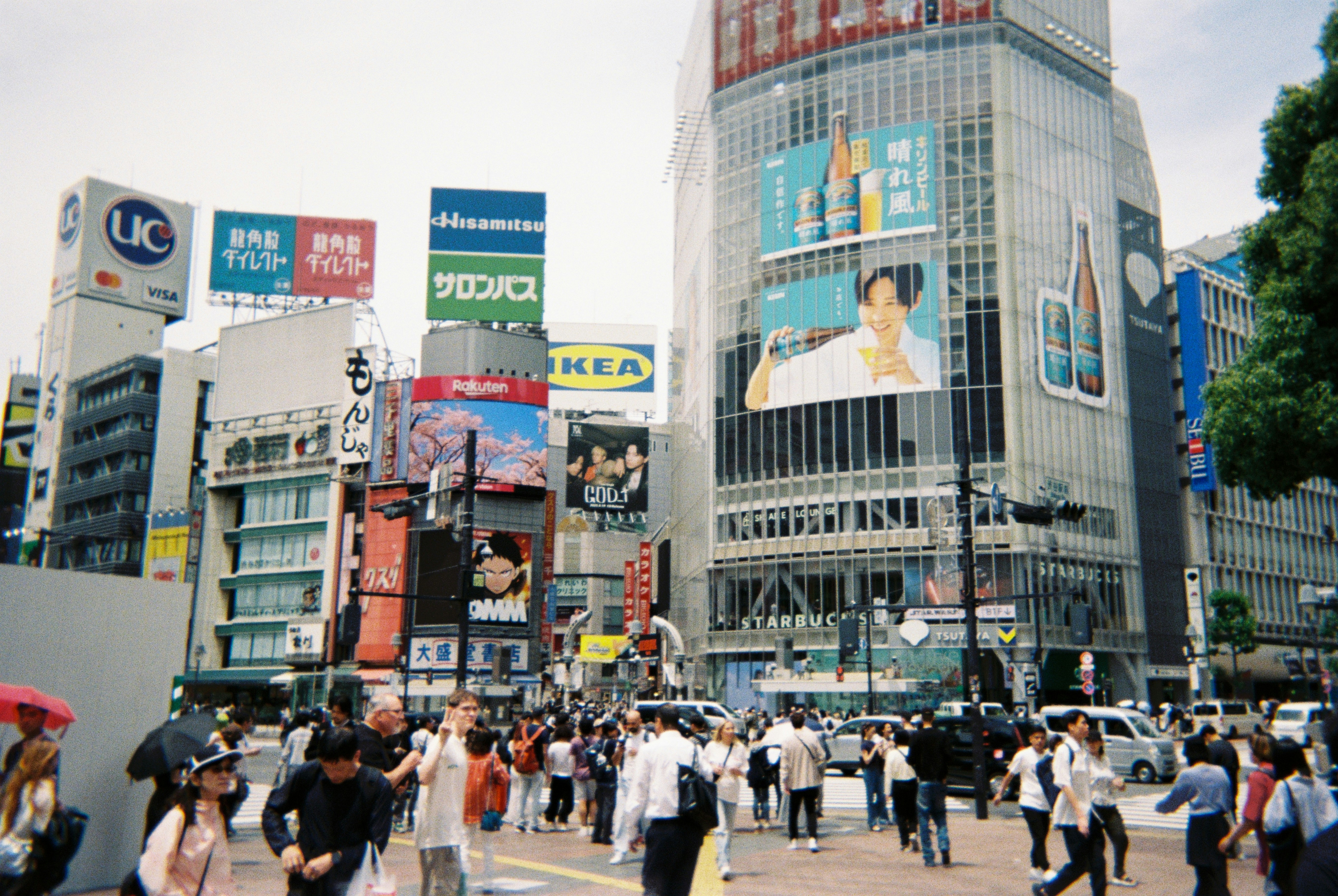 Bustling city street with many people and bright billboards.
