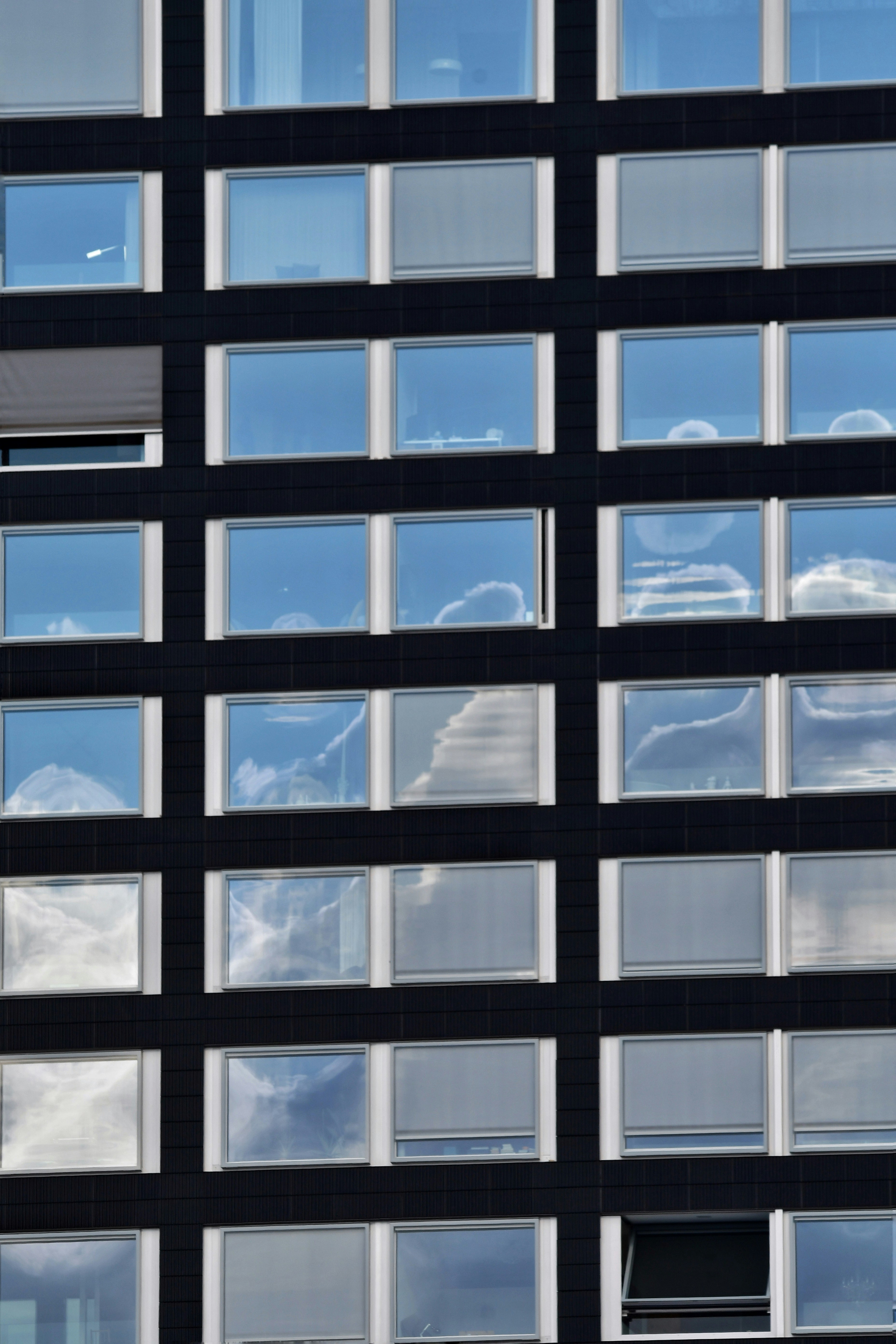 Reflections of clouds in a modern building's windows